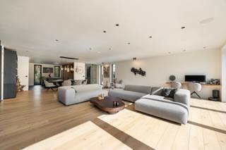 Deze gelijkvloerse villa in Aartselaar ligt op een perceel van 1.593 m² en combineert een ruime woning met een groot magazijn. De woning heeft een open indeling, grote glaspartijen en veel natuurlijk licht.<br /><br />Via de inkomhal met grote glazen deur kom je binnen in de woning. Hier bevinden zich een ingemaakte vestiaire en een gastenwc met smart-toilet. De ruime eetkamer sluit aan op de woonkamer met zicht op de tuin. De volledig uitgeruste keuken is voorzien van inbouwtoestellen en sluit aan op een technische berging.<br /><br />De master bedroom beschikt over een geïntegreerde badkamer met ligbad en dubbele regendouche én een volledig ingebouwde dressing met wasruimte. De tweede slaapkamer heeft eveneens een eigen badkamer met douche.<br /><br />Verder beschikt de woning over vloerverwarming, domotica, geïntegreerd geluidsysteem en een conforme elektrische installatie.<br /><br />Buiten is er een aangenaam terras en een volwassen, groen aangelegde tuin (zwembad mogelijk). Aan de woning is er een oprit met plaats voor drie wagens en een laadpaal.<br /><br />Naast de villa bevindt zich het ruime magazijn, voorzien van een toilet en douche. Het magazijn beschikt ook over een verdieping, wat extra opslag- of werkruimte biedt. De ruime oprit (circa 180m²) aan het magazijn zorgt voor voldoende manoeuvreerruimte.<br /><br />Extra troeven:<br />- Gelijkvloerse villa<br />- Perceel van 1.593 m²<br />- Ruim magazijn met verdieping<br />- Ruime oprit aan het magazijn<br />- Oprit aan de woning voor drie wagens<br />- Laadpaal<br />- Twee slaapkamers met elk een eigen badkamer<br />- Grote glaspartijen<br />- Aangename tuin en terras<br />- Mogelijkheid tot zwembad<br />- Vloerverwarming<br />- Domotica<br />- Surround geluidssystemen<br />- Conforme elektrische installatie<br />- 20 zonnepanelen<br />- EPC A (BEN-woning met E-peil van 21)<br />- Enkele jaren vrijgesteld van onroerende voorheffing<br />- Aanwezige camerabewaking, zonder abonnement<br /><br />Graag meer info of een bezoek gewenst?<br />Contacteer ons via 0492 83 88 19 of jarno@groepvanhaute.be