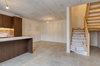 Droomt u van wonen op een plek met ziel en geschiedenis? Ontdek nieuwbouwproject De Katte in het charmante Sint-Martens-Bodegem (Dilbeek). Deze iconische, voormalige brouwerij in de schaduw van de kerktoren is met respect voor het verleden getransformeerd tot een prachtig hedendaags woonerf. Hier vloeien authentieke karakterelementen naadloos samen met moderne luxe en wooncomfort.Met reeds 10 verkochte units gaat het hard, maar u kan nog eigenaar worden van een stukje geschiedenis. Er zijn momenteel nog slechts 6 exclusieve units beschikbaar. Of u nu zoekt naar een ruim appartement of een royale loft, met opties van 2 tot maar liefst 5 slaapkamers vindt u hier de perfecte match. Elke unit is voorzien van een hoogwaardige afwerking en beschikt over een prachtig terras of privatieve buitenruimte om in alle rust te genieten van de omgeving.De Katte is volledig klaar voor de toekomst en uitgerust met state-of-the-art geothermische verwarming en passieve koeling. Een duurzame investering die uw wooncomfort garandeert, zomer en winter. Bovendien is het project volledig opgeleverd: de appartementen zijn meteen beschikbaar.Dit renovatieproject komt in aanmerking voor het verlaagde 6% BTW-tarief (in plaats van 21% op nieuwbouw). Dit levert u een aanzienlijk financieel voordeel op van tienduizenden euro's!