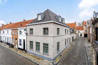<p>Op een toplocatie in de historische binnenstad van Brugge, op wandelafstand van de Grote Markt, vind je deze unieke en instapklare woning. Geniet van het levendige stadsleven én een vlotte bereikbaarheid dankzij de nabijheid van de Brugse ring.</p>

<p>Deze woning werd volledig nieuw opgetrokken in 2019 en voldoet aan de hoogste moderne woonstandaarden. Geen renovatie, maar een eigentijds woonconcept met een uitzonderlijk lage EPC-waarde van 65 (label A). Elk detail werd ontworpen met oog voor duurzaamheid en comfort.</p>

<p>De ruime inkomhal met gastentoilet leidt je naar een lichtrijke leefruimte en een volledig uitgeruste keuken, die uitkomt op een gezellige stadstuin. Het gelijkvloers omvat verder een aparte wasruimte/berging en een ruime garage met laadpunt, waarvan de ramen kunnen openen om een binnenterras te creëren.</p>

<p>Op de eerste verdieping bevinden zich een open bureauruimte, douchekamer, nachttoilet, twee slaapkamers (waarvan één met ensuite badkamer met ligbad én douche) en een zonneterras. De tweede verdieping biedt nog twee kamers, waarvan één momenteel dienstdoet als dressing.</p>

<p>Extra troeven zijn onder andere domotica, driedubbele beglazing met aluminium profielen, ventilatiesysteem D, vloerverwarming en energiezuinige convectoren.</p>

<p>Een zeldzame kans om modern, energiezuinig en stijlvol te wonen in een van de mooiste steden van Vlaanderen. Neem vandaag nog contact op voor een bezoek!</p>