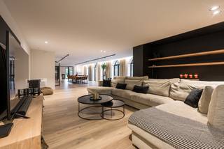 Verscholen in een oase van rust en groen, bereikbaar via een private oprijlaan, bevindt zich deze architectenvilla van de hand van architect J.C. Bols op 13.815 m² grond. Een eigendom waar discretie en hedendaags wooncomfort harmonieus samenkomen, op een toplocatie op slechts enkele minuten van het centrum van Turnhout. Deze imposante villa werd in 2020 quasi volledig gerenoveerd met respect voor haar karaktervolle architectuur, en afgewerkt met hoogwaardige materialen doorheen de volledige woning. Het resultaat is een instapklare villa met een tijdloze uitstraling, ontworpen voor wie comfortabel wil wonen in volledige privacy.<br /><br />Bij het betreden van de woning verwelkomt een stijlvolle inkomhal u in een wereld van elegantie en ruimte. Er is een praktische bureauruimte aanwezig, te bereiken vanuit deze inkomhal. De royale leefvertrekken baden in natuurlijk licht en genieten van een prachtig zicht op het omliggende groen. De sfeervolle zithoek met geïntegreerd maatwerk en uitnodigende eetkamer creëren een warm en verfijnd geheel. De volledig vernieuwde leefkeuken vormt het hart van de woning en is uitgerust met alle hedendaagse comfort voorzien van alle moderne apparatuur. De aanpalende ontbijtruimte geeft rechtstreeks toegang tot het terras.<br /><br />De villa beschikt over vijf volwaardige slaapkamers en twee badkamers. De mastersuite omvat een recent vernieuwde badkamer en dubbele dressing. Een aparte vleugel met eigen toegang en trap biedt bijkomende mogelijkheden als gastenverblijf of kantoor.<br /><br />De zolderverdieping strekt zich uit over de volledige woning en biedt veel potentieel voor extra slaapkamers of hobbyruimte.<br /><br />Ook op praktisch vlak voldoet deze eigendom aan de hoogste verwachtingen, met onder meer een dubbele inpandige garage, ruime kelderverdieping inclusief wijnkelder, alarm, airconditioning en een duurzame energievoorziening dankzij zonnepanelen met batterijopslag.<br /><br />Het volledig omheinde domein omvat een prachtig aangelegde tuin met meerdere natuurstenen terrassen, een sfeervol paviljoen met open haard, ruime parkeergelegenheid en een weiland met dierenstal. Een zeldzame plek waar rust, natuur en absolute privacy centraal staan.<br /><br />Bijzonderheden: <br />- zeer mooi gelegen, in het groen, aan de rand van Turnhout. <br />- de villa werd gerenoveerd in 2020 en werd hedendaags afgewerkt<br />- groot woonvolume van 557 m²<br />- verwarming dmv van propaangas (deels vloerverwarming en deels radiatoren)<br />- 24 zonnepanelen en batterij aanwezig