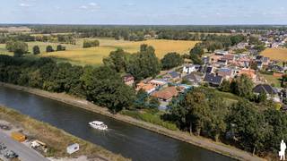 <p><strong>Op een bijzonder aangename locatie aan de rand van Ravels, vlak bij de dijk van het kanaal Dessel–Schoten, bevindt zich deze verrassend ruime en uiterst gezellige woning. De rustige, groene omgeving vormt hier een absolute troef, terwijl het centrum van Ravels, Turnhout en de rest van de Kempen vlot bereikbaar blijven. De woning is gelegen op een zuidwest georiënteerd perceel van 765 m² en combineert een warme woonbeleving met heel wat praktische ruimte. Met onder meer vier slaapkamers, een vernieuwde keuken, twee garages, een afgesloten atelier, carport en een gunstig EPC-label C (231 kWh/m²) is dit een bijzonder complete gezinswoning.</strong><br /><br />Gelijkvloers: <br />Via de inkomhal met ruimte voor vestiaire komt u in de royale leefruimte. De ruime zithoek, afgewerkt met zachte beige vloertegels, vormt een gezellige plek om tot rust te komen. De pelletkachel versterkt het warme karakter en vanuit de woonkamer geniet u via de tuinkamer van een mooi zicht op de achterliggende tuin. Aansluitend bevindt zich de centraal gelegen eetkamer, met voldoende plaats voor een grote tafel waar u uitgebreid kunt tafelen met familie en vrienden. Aan het raam werd bovendien een praktische bureauhoek ingericht, waardoor thuiswerken of studeren perfect geïntegreerd is in de leefruimte. De recent vernieuwde keuken vormt het hart van de woning. Ze werd eigentijds en kwalitatief ingericht met alle nodige toestellen en beschikt over een royaal natuurstenen werkblad. Vanuit de keuken bereikt u rechtstreeks de sfeervolle tuinkamer. Dankzij de grote schuifpui loopt binnen hier naadloos over in buiten en geniet u optimaal van de tuin en de gunstige zuidwestelijke oriëntatie. Naast de keuken bevindt zich een ruime en praktisch ingerichte wasplaats/bijkeuken met maatwerkkasten, voldoende werk- en bergruimte en een rechtstreekse verbinding met de inpandige garage. Ook het gelijkvloers biedt bijzonder veel wooncomfort. Hier bevinden zich twee ruime slaapkamers en een verzorgde badkamer met dubbele wastafel en inloopdouche. Hierdoor is gelijkvloers wonen perfect mogelijk.</p>
<p>Op de verdieping geeft de nachthal met afzonderlijk toilet toegang tot nog eens twee volwaardige slaapkamers. Bovendien werd reeds een vooraanleg voorzien voor de realisatie van een tweede badkamer, wat extra mogelijkheden biedt voor grotere gezinnen.</p>
<p>Ook buiten is het aangenaam vertoeven. De afgesloten tuin beschikt over een verzorgd grasperk en biedt volop privacy en ruimte om van zonnige dagen te genieten. Daarnaast zijn er een tweede garage met aansluitend atelier/tuinberging, een carport en een ruime, degelijke oprit met voldoende parkeergelegenheid.</p>
<p>Een warme en veelzijdige woning voor wie houdt van rust, ruimte en groen, met het kanaal en de prachtige Kempense omgeving letterlijk vlakbij, zonder in te boeten aan bereikbaarheid richting Ravels, Turnhout en omliggende gemeenten.<br />Optioneel bij te huren aan 180€/jaar 200m² op de dijk voor eventuele groententuin, houden van kippen of extra parking via Vlaamse Waterwegen.</p>