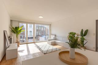 Welkom in dit appartement op het 1ste verdiep van een goed onderhouden gebouw! Via een stevige veiligheidsdeur kom je in een ruime, open hal terecht. Van hieruit betreed je een grote leefruimte met kamershoge ramen langswaar het zonlicht overvloedig binnenstroomt. De ramen zelf zijn slechts enkele jaren geleden geplaatst. De keuken en badkamer zijn recent gerenoveerd en de elektrische installatie is hierbij conform gemaakt. De twee slaapkamers liggen aan de achterkant waar het rustig vertoeven is.<br /><br />In de buurt van de woning liggen er tal van restaurantjes, bakkerijen, slagers en andere zaken uit alle hoeken van de wereld. Het Centraal Station ligt slechts op enkele minuten wandelafstand. En dankzij haar centrale ligging ben je zo in het historisch centrum waar je lekker kunt shoppen of culturele hotspots kunt bezoeken.<br /><br />Wordt dit je toekomstig stulpje? Kom het snel ontdekken!<br /><br /><br /><strong>Indeling</strong><br />Hal (4,8 m²).<br />Leefruimte (37,2 m²).<br />Keuken (7,5 m²).<br />Toilet.<br />Douchekamer (4,2 m²).<br />Slaapkamer 1 (10,2 m²).<br />Slaapkamer 2 (16,0 m²).<br />Terras (3,2 m²)<br /><br />Kelderberging (6 m²).<br /><br /><strong>Extra</strong><br />Gemeenschappelijke kosten: 230 euro/maand (syndicus, blokpolis, onderhoud liften, enz.) + 140 euro/maand (verwarming en water).<br />Aparte meter voor elektriciteit.  <br />Elektrische installatie: AREI-conform.<br />EPC: B.<br /><br />(woongebied, vergunning, geen verkavelingsvergunning, voorkooprecht, geen rechterlijke herstelmaatregel)