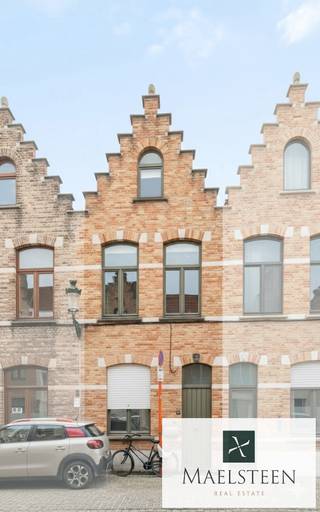 In een rustig, schilderachtig straatje in Brugge, met authentieke kasseien, bevindt zich deze instapklare stadswoning met een trapgevel uit 1906. Het pand werd recent volledig vernieuwd en afgewerkt met oog voor detail, waardoor het een zeldzame combinatie biedt van historische charme en hedendaags wooncomfort.<br /><br />Samenstelling:<br />Op het gelijkvloers bevindt zich de inkomhal en een volledig ingerichte open keuken aan de straatzijde. De leefruimte ademt gezelligheid uit dankzij de lambrisering, de sfeervolle inbouwverlichting en de lichtrijke uitbouw met een grote glaspartij en schuifraam dat uitgeeft op een zalig, zuidgericht terrastuintje. Achteraan werd een ruime berging in padouk voorzien. Tuin en tuinberging heraangelegd in 2024.<br />Op de eerste verdieping is er de master bedroom met ingewerkte kastenwand en een stijlvolle badkamer (vernieuwd in 2024) met inloopdouche, lavabomeubel en toilet. Op de tweede verdieping bevinden zich een tweede slaapkamer en een bijkomende berging/derde slaapkamer. <br /><br />Deze woning onderscheidt zich door haar unieke ligging in een pittoreske straat, de historische gevel die het Brugse karakter benadrukt en de hoogwaardige renovatie die het geheel volledig instapklaar maakt. Het is een perfecte match voor wie houdt van authenticiteit zonder in te boeten aan comfort en functionaliteit.<br /><br />Neem zeker contact op met al uw vragen of om uw persoonlijke afspraak (7/7) vast te leggen: 0478 93 72 00 of maxime@maelsteen.be