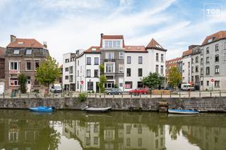 Op een boogscheut van het bruisende centrum van Gent bevindt zich dit instapklare duplexappartement met één slaapkamer, gelegen in een gebouw dat in 2023 volledig werd gerenoveerd. <br /><br />Het appartement is verdeeld over twee verdiepingen en beschikt over een aangename, lichtrijke leefruimte, keuken, badkamer en een ruime slaapkamer met aansluitend het gezellige terras, waar je in alle rust kunt genieten van een koffie en even kunt ontsnappen aan de drukte van de stad.<br />Dankzij de aanwezige airconditioning geniet je ook tijdens de warmere maanden van een aangenaam binnentemperatuur.<br /><br />Met EPC-label B, een volledig gerenoveerd gebouw en een centrale ligging nabij het historische centrum beschikt dit appartement over alle troeven voor het stadsleven.<br /><br />Er is geen professionele syndicus aangesteld. Het beheer gebeurt onderling tussen de eigenaars, waardoor er geen vaste maandelijkse syndicale kosten zijn. Enkel de blokpolis en enkele beperkte gemeenschappelijke kosten worden doorheen het jaar verdeeld.<br /><br />Beschikbaar bij akte!<br /><br />Contacteer Top Vastgoed voor een bezoek op 0475 700 700!