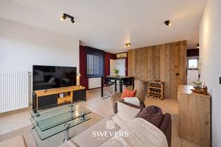 Voor meer info en foto’s, surf naar www.swevers.be – Op Markt 17 bus 7 in Heppen bevindt zich dit ruime appartement met een bewoonbare oppervlakte van 55 m². Het appartement dateert van 1996, verkeert in opgefriste staat en combineert een praktische indeling met twee aangename terrassen. De leefruimte van maar liefst 42,46 m² vormt het centrale gedeelte van het appartement en biedt voldoende plaats voor een volwaardige zit- en eethoek. Aansluitend bevindt zich de gedeeltelijk open keuken van 6,21 m². Grote raampartijen zorgen voor veel contact met het langgerekte terras, dat zich over nagenoeg de volledige breedte van het appartement uitstrekt. Verder beschikt het appartement over één slaapkamer van 9,67 m², met toegang tot een tweede en ruimer terras. Naast de slaapkamer ligt de badkamer met douche en wastafel. Het toilet bevindt zich praktisch in een afzonderlijke ruimte. Extra comfort wordt geboden door airconditioning, jaloezieën, lift in het gebouw en aparte garagebox. Ook de ligging is praktisch: restaurants bevinden zich vanaf circa 100 meter, openbaar vervoer op 300 meter, scholen op 450 meter en winkels op ongeveer 650 meter. De snelwegen liggen op circa 8 kilometer. Een ruim appartement met een grote living, twee terrassen en een centrale ligging in Heppen. Ideaal voor wie comfortabel wil wonen met alle nodige voorzieningen binnen handbereik. Voor meer informatie, bel 011 255 155. Bron bewoonbare oppervlakte: EPC – verslag.
