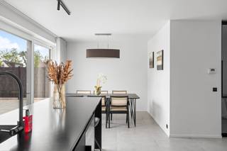 <p>Bent u op zoek naar de perfecte balans tussen een centrale ligging, modern comfort en een sfeervolle, smaakvolle inrichting? Deze recente en trendy 3-gevelwoning uit <strong>2024</strong> biedt het allemaal. Gelegen in de directe nabijheid van scholen en het bruisende centrum, en met een uitstekende verbinding naar de <strong>A12</strong>, geniet u hier van een toplocatie waar mobiliteit en rust hand in hand gaan.</p><p>Dankzij de high-end afwerking, een doordachte indeling en de integratie van een modern <strong>domoticasysteem</strong> is deze woning volledig klaar voor de toekomst.</p><h3>Een sfeervol en warm welkom</h3><p>Bij het betreden van de woning wordt u meteen verwelkomd in de stijlvolle inkomhal met gastentoilet. Doorlopend bereikt u de <em>cozy</em> leefruimte, die warmte en rust uitstraalt—de ideale plek voor een gezellig avondje voor de buis.</p><p>Aansluitend bevindt zich de absolute eyecatcher van het huis: de royale <strong>leefkeuken</strong>. Dit is een ware droom voor elke kookliefhebber. Uitgerust met hoogwaardige toestellen, een ingebouwde <strong>wijnkoeler</strong> en een riant kookeiland, leent deze ruimte zich perfect voor uitgebreid tafelen met vrienden en familie. Wat deze keuken écht uniek maakt, is het panoramische uitzicht op de tuin; een levend schilderij dat in elk seizoen een nieuwe belevenis biedt.</p><p>Praktisch comfort is er ook: de inpandige garage biedt niet alleen plaats voor de wagen, maar fungeert tevens als handige wasplaats en extra berging.</p><h3>Ruimte, comfort en flexibiliteit op de verdiepingen</h3><p>Op de eerste verdieping leidt de nachthal met apart toilet naar drie volwaardige slaapkamers. De <strong>master bedroom</strong> is een luxe suite op zich, compleet met een eigen, op maat gemaakte <strong>dressingkamer</strong>. De badkamer trekt de lijn van hoogwaardige afwerking feilloos door en is voorzien van alle comfort, waaronder een royale <strong>XL-douche</strong>.</p><p>Via een vaste trap bereikt u de reeds geïsoleerde en volledig afgewerkte <strong>zolderverdieping</strong>. Deze doet momenteel dienst als polyvalente ruimte, maar biedt de flexibiliteit om heel eenvoudig omgevormd te worden tot <strong>2 extra slaapkamers</strong> of een riant thuiskantoor.<br /><br /><strong>RICHTPRIJS 595.000€</strong></p><h3>Strakke buitenomgeving</h3><p>Buiten is het genieten in de prachtig aangelegde tuin. De combinatie van de zorgvuldig gekozen beplanting en het strakke terras in <strong>gepolierde beton</strong> geeft het geheel een moderne, architecturale uitstraling en vraagt bovendien weinig onderhoud.</p><h3>De troeven in een oogopslag:</h3><ul><li><p><strong>Bouwjaar 2024:</strong> Volledig up-to-date, energiezuinig en instapklaar.</p></li><li><p><strong>High-end technieken:</strong> Uitgerust met domotica en een slimme, doordachte indeling.</p></li><li><p><strong>Droomkeuken:</strong> Voorzien van luxe-toestellen, wijnkoeler en een groot eiland.</p></li><li><p><strong>Ruimte & Potentieel:</strong> 3 slaapkamers (inclusief dressing) met de mogelijkheid tot 5 kamers dankzij de ingerichte zolder.</p></li><li><p><strong>Toplocatie:</strong> Nabij scholen, centrum en een vlotte verbinding met de A12.</p></li></ul><blockquote><p><strong>Bent u net zo enthousiast als ik?</strong> Laat deze unieke kans niet aan u voorbijgaan en plan vandaag nog uw bezoek.</p></blockquote><p></p>