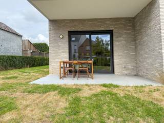 Mooi RECENT lichtrijk appartement bestaande uit een hall, living met open ingerichte keuken, wasberging, 2 slaapkamers, badkamer, apart toilet, terras met tuin vooraan / zijkant / achteraan, carport met berging, private parkeerplaats, 2 fietshaken. Wordt volledig geschilderd verhuurd en voorzien van verlichtingsarmaturen. Hoge plafonds, vloerverwarming en ventilatiesysteem. (60 euro syndiek)