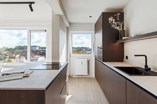 <p>Welkom in jouw nieuwe thuis! Op de vijfde verdieping van deze piekfijn onderhouden residentie, die bovendien de naam ‘De Merode’ draagt, ontdek je dit prachtige appartement.</p>
<p>Met een oog voor stijl én detail werd elke ruimte zorgvuldig vernieuwd met gebruik van kwaliteitsvolle materialen! Dit komt volledig tot zijn recht in de lichtrijke leefruimte welke werd voorzien van een mooie, natuurlijke eiken parket, die naadloos doorloopt tot in de luxueuze open keuken. Deze is uitgerust met hoogwaardige materialen waaronder het keramische werkblad en werd daarnaast in een trendy notelaar-jasje gestoken, wat zorgt voor een verfijnde look-and-feel! Verder zijn er 3 slaapkamers (14 m², 10 m² &amp; 8 m²) die rechtstreeks toegang bieden tot 2 uiterst zonnige terrassen, dé ideale plek voor ontspanning! Tot slot is er nog een praktische berging voorzien met aansluitingen voor was- en droogmachine én uiteraard een stijlvolle badkamer met een ruime inloopdouche, dubbele lavabo in meubel en handdoekradiator. Het toilet is apart.</p>
<p>Kortom, een instapklaar pareltje waar je enkel nog hoeft uit te pakken en te genieten!</p>
<p>Mogelijkheid tot het aankopen van een <strong>autostaanplaats</strong> à € 15.000,00. <br /><strong>Fietsenstalling</strong> <strong>aanwezig</strong>: via de automatische garagepoort rijd je moeiteloos naar binnen!</p>
<p><strong>Maandelijkse kosten: </strong>€ 220,00 (inclusief verwarming, water, dagelijkse schoonmaak, <strong>inwonende</strong> <strong>conciërge</strong>, onderhoud lift, etc.)</p>
<p><strong>Technische gegevens: kelderberging aanwezig! </strong>10 jaar garantie op de keukenkasten + 5 jaar garantie op de toestellen! High-end ledverlichting met 5 jaar garantie, alle sanitaire en elektrische leidingen werden vernieuwd, inclusief verlichting. Verwarming op gas (collectief) via een condenserende ketel, HR-beglazing in aluminium.</p>
<strong>Stedenbouwkundige inlichtingen en bodemattest in aanvraag. Asbestveilig (maar mogelijk niet asbestvrij). Bevindt zich niet in een risicozone voor overstromingen (P-score D en G-score C). Renovatieverplichting niet van toepassing.</strong>