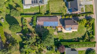 Aan de rand van Sint-Niklaas, op een steenworp van Waasmunster, bevindt zich deze open bebouwing op een uitzonderlijk <strong>ruim perceel van maar liefst 4.051 m²</strong>. Een woning uit 1984 die doorheen de jaren met zorg werd onderhouden en vernieuwd, waardoor ze vandaag beschikt over een degelijke bouwkundige basis, een EPC-label B en een conforme elektrische installatie.<br /><br />De eigendom onderscheidt zich echter vooral door haar uitzonderlijke mogelijkheden. Op het perceel bevindt zich een <strong>loods van circa 260 m²</strong>, ideaal voor wie wonen en werken wil combineren, nood heeft aan opslag of op zoek is naar een eigen werkplek. Bovendien verkregen de eigenaars een <strong>vergunning voor de bouw van een nieuw KMO-gebouw van 510 m²</strong>, na afbraak van de bestaande loods.<br /><br />De woning zelf verwelkomt u via een ruime inkomhal met vestiairemogelijkheden en een apart toilet. <strong>Op het gelijkvloers bevindt zich bovendien een slaapkamer</strong>, die zich evengoed leent als bureau of hobbyruimte.<br /><br />De leefruimtes vormen het warme hart van de woning. De woon- en eetkamer lopen naadloos over in de veranda, een aangename ruimte die baadt in het natuurlijke licht en uitkijkt over de uitgestrekte tuin. Hier ontstaat een vanzelfsprekende verbinding tussen binnen en buiten, met ruimte voor lange tafelmomenten, rustige ochtenden en het dagelijkse gezinsleven. De halfopen keuken sluit praktisch aan op de leefruimtes en beschikt over een aansluitende berging en wasplaats. Een functionele indeling die comfort en gebruiksgemak centraal stelt.<br /><br />Op de verdieping bevinden zich nog twee slaapkamers en een badkamer. Deze werd uitgerust met zowel een ligbad als een douche.<br /><br />Als leuke extra rusten er bovendien nog <strong>groenestroomcertificaten</strong> (€210) op de zonnepanelen en dit tot en met 2032. <br /><br />Wilt u deze woning graag ontdekken? Of wenst u meer informatie over de vergunning en de mogelijkheden voor het nieuwe KMO-gebouw? Neem dan gerust contact op via laurens@claves.be of 0476 21 35 46.