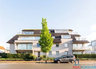 <strong>Sint-Idesbald, Residentie Noor, Prachtig appartement met hoogstaande afwerking en zonnig terras, 3e verdieping met lift.</strong><br />Bestaande uit: inkomhall met ingebouwde vestiairekast, afzonderlijk toilet, lichtrijke woonkamer met zonnig terras met mooi uitzicht, moderne ingerichte open keuken voorzien van alle toestellen, afzonderlijke berging met aansluiting wasmachine en droogkast, slaapkamer met ensuite badkamer die bestaat uit ingebouwde dubbele wastafel, douche en toilet en tweede slaapkamer met douche en wastafel. Het appartement is volledig in parket en voorzien van individuele centrale verwarming op aardgas. Gemeenschappelijke fietsenberging in de residentie. Mogelijkheid tot het aankopen van een zeer ruime garage in de residentie tegenover. <br /><br />Dit residentieel appartement is rustig gelegen vlakbij zee en het commerciële centrum.