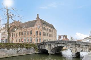 In de historische Spanjaardstraat, gelegen nabij de Augustijnenrei, bevindt zich dit unieke appartement in de prestigieuze Residentie Villa Medici.Bij het binnenkomen in dit historische pand, waarvan de oorsprong van de gevel teruggaat tot de 17e eeuw, valt direct de harmonie tussen geschiedenis en moderniteit op. Waar het gebouw vroeger statige grandeur uitstraalde, is het inmiddels volledig vernieuwbouwd tot een hedendaagse parel. De ruimtes genieten van een hoogwaardige afwerking die de authentieke ziel van de Brugse binnenstad perfect combineert met alle modern comfort.Indeling:-1°V.: Kelderberging (04)Glvl.:- Staanplaats (8) € 49.000,002°V.:- Inkomhal met apart toilet- Een sfeervolle woonkamer die rust en authenticiteit uitstraalt.- Open keuken, volledig ingericht- Slaapkamer- Badkamer voorzien van eigentijds sanitair en kwalitatieve materialen.De ligging nabij de Augustijnenrei maakt het plaatje compleet. U woont hier in een oase van rust, terwijl de historische markt, de reitjes en de gezellige Brugse pleinen letterlijk om de hoek liggen.
