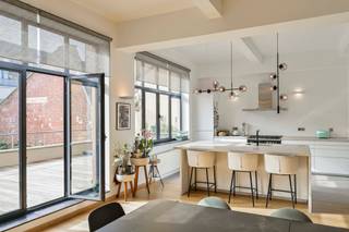 <strong>BERCHEM-SAINTE-AGATHE </strong>– À proximité immédiate du Hoogveld et du Ring – Niché au sein de l’ancienne quincaillerie industrielle Roussel &amp; Servais datant des années 1910, ce splendide loft de caractère de ±190m² habitables séduit par son authenticité, ses volumes exceptionnels et son élégante rénovation contemporaine.<br /><br />Véritable témoin du patrimoine industriel bruxellois, ce bien unique conjugue à merveille le charme de l’architecture industrielle d’origine et des finitions haut de gamme soigneusement sélectionnées : briques apparentes, superbes structures métalliques, parquet en chêne massif, magnifiques interrupteurs en laiton et lumière omniprésente grâce aux larges ouvertures de style atelier.<br /><br />Le loft s’ouvre sur une remarquable cage d’escalier privative menant vers un spectaculaire espace de vie de ±90m² baigné de lumière, comprenant un vaste living et une somptueuse cuisine entièrement équipée avec îlot central. L’ensemble offre une atmosphère chaleureuse et résolument architecturale.<br /><br />La partie nuit se compose d’une magnifique chambre parentale de ±28m² avec salle de douche privative, d’une seconde chambre de ±12,5m², d’une élégante salle de bains ainsi que d’une buanderie.<br /><br />À l’extérieur, une superbe terrasse orientée plein SUD prolonge harmonieusement les espaces de vie et offre un véritable havre de paix en milieu urbain. PEB: D-, 210 kwh/(m².an). <br /><br />Un bien rare et singulier, destiné aux amateurs d’architecture, de volumes atypiques et de lieux chargés d’histoire.<br />BIEN UNIQUE, A VISITER SANS TARDER ! <br /><br /><span>Au 1er étage :</span><br />
<ul>
<li>Hall d'entrée</li>
<li>Living de ± 90m² - Parquet massif</li>
<li>Cuisine USA super équipée</li>
<li>Terrasse de ± 40m² orientée Sud</li>
<li>Salle de bains (baignoire, lavabo)</li>
<li>WC séparé</li>
<li>Chambre 1 de ± 28m² avec salle de douche privative et dressing encastré - Parquet massif</li>
<li>Chambre 2 de ± 12,5m² - Parquet massif</li>
<li>Buanderie avec chaudière de 2025</li>
</ul>
Cave n°2<br /><br />Provision charges : 275€/ mois (frais communs)<br /><br />PEB : D-, 210kWh/ (m²/an)