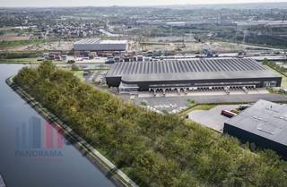 <strong>Logistiek magazijn </strong>binnen een nieuw project met 12.053 m² opslagruimte, 1.174 m² kantoorruimte en 2.297 m² mezzanine te huur.<br /><br />De site beschikt over een rechtstreekse trimodale toegang (water, spoor en weg). Dankzij de vlotte aansluiting op de E42 (1 km) en de E19 (4 km), evenals de nabijheid van de luchthavens van Charleroi, Brussel en Luik, geniet de locatie van een uitstekende nationale en internationale bereikbaarheid.<br /><br />De unit heeft een <strong>vrije hoogte van 13,7 m </strong>en een vloerbelasting tot 50 kN/m². De betonnen plint van 2,50 m en de ruime manoeuvreerruimte van 40 m garanderen een vlotte logistieke afhandeling, een<strong> sectionale poort (4 x 6 m) </strong>en laad- en loskades met nivelleerder (1 per 1.000 m²), wat een efficiënte goederenstroom mogelijk maakt.<br /><br />Verder biedt het gebouw een hoog comfort- en veiligheidsniveau met airconditioning, LED-verlichting (200–250 lux en 250–500 lux), een hoogspanningscabine van 400 kVA, een elektrisch bediende slagboom en ruime autoparkeerplaatsen. Op het vlak van brandveiligheid is de unit uitgerust met ESFR-sprinklers, branddetectie, een brandalarmsysteem en brandslangenhaspels.<br /><br />Contacteer<strong> PANORAMA B2B</strong> voor bijkomende informatie, plannen of een vrijblijvend plaatsbezoek <strong>0479 70 70 70</strong><br />