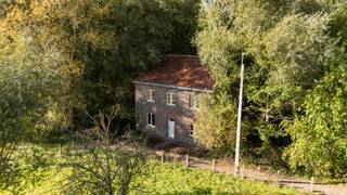 <p><strong>Ben je op zoek naar een volledig te renoveren open bebouwing met een uitzonderlijk rustige ligging in Roosdaal? Gevonden! </strong></p>

<p><span>Helemaal op het einde van een doodlopende straat, omringd door natuur en verschillende wandelpaden, bevindt zich deze eigendom voor wie rust en privacy centraal staan. Met de eerste buren op ongeveer 100 meter afstand en Brussel op amper 20 km geniet je hier van een bijzonder afgelegen ligging, met de hoofdstad toch binnen bereik. De woning vraagt een totaalrenovatie en richt zich tot wie een grondig renovatieproject zoekt op een bijzondere plek. De woning is zonevreemd gelegen. Aansluitingen op aardgas, de openbare riolering en het stadswater ontbreken. Op het perceel bevindt zich bovendien een natuurlijke bron.</span></p>

<p>Op het gelijkvloers vind je een inkomhal, een leefruimte met aansluitende keuken en een extra kamer die kan dienen als bureau, slaapkamer of hobbyruimte. De eerste verdieping heeft drie slaapkamers en <span>een vaste trap naar de </span>zolder. Daarnaast is de woning volledig en geeft deze rechtstreeks uit op de grote tuin, waar je volop kunt genieten van de groene omgeving.</p>

<p><strong>Zie jij de mogelijkheden om hier jouw eigen woonproject te realiseren? Contacteer ons voor meer informatie of een bezoek!</strong></p>
