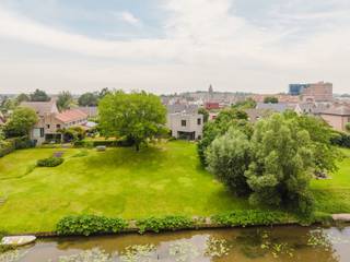 Ligging<br /><br />Deze uitzonderlijke villa bevindt zich op een prachtige locatie in Astene, waar rust, natuur en architectuur perfect samenkomen. De woning geniet van een uniek uitzicht op de Leie en de achterliggende velden, waardoor u dagelijks kunt genieten van een open en groen landschap. Tegelijkertijd bent u vlot verbonden met Deinze, Gent en de belangrijkste invalswegen.<br /><br />Indeling<br /><br />Op het gelijkvloers bevindt zich een ruime inkomhal, een praktische berging/wasplaats en een afzonderlijk bureau met toegang tot een terras, ideaal voor thuiswerk of een zelfstandige activiteit. Verder vindt u er een indrukwekkende leefruimte met een ruime open keuken die naadloos aansluit op het terras en de tuin.<br /><br />De tuin vormt zonder twijfel één van de absolute hoogtepunten van deze woning. Vanuit de woning geniet u van een prachtig open zicht over het groen, terwijl de tuin doorloopt richting de Leie en een unieke buitenbeleving creëert.<br /><br />Daarnaast beschikt de woning over een grote kelder, ideaal voor opslag.<br /><br />Op de eerste verdieping bevinden zich vier volwaardige slaapkamers, een ruime badkamer, een afzonderlijke douchekamer en een praktische dressing.<br /><br />Troeven<br /><br />Prachtig zicht op de Leie en achterliggende velden<br />Lichtrijk<br />Unieke woonbeleving<br />Beschikbaar vanaf 1 oktober<br /><br />Onderhoud tuin: 200 EUR/maand<br /><br />Een uitzonderlijke villa voor wie op zoek is naar architectuur, ruimte, licht en een unieke ligging aan het water.