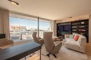 Stijlvolle duplex-penthouse op een absolute toplocatie aan het Albertplein in het hart van het Zoute biedt een zeldzame combinatie van zonovergoten terrassen, open panoramische zichten en hoogstaande afwerking.<br /><br />indeling van het appartement:<br />ruime inkomhal met ingebouwde vestiaire en een gastentoilet. De lichtrijke leefruimte bestaat uit een gezellige salonhoek en een eetplaats, beide uitgevend op een zuidwest-georiënteerd terras dat uitzicht biedt over het bruisende Albertplein.<br /><br />De volledig uitgeruste open keuken sluit naadloos aan op de eetruimte en geeft toegang tot een ruim achterliggend terras. Hier kan u 's morgens in alle rust genieten van de zon en een groen vergezicht richting de Approach Golf. Op dit niveau bevindt zich ook een eerste slaapkamer, voorzien van ingemaakte kasten en een eigen douchekamer met inloopdouche en lavabo. Daarnaast is er een praktische berging.<br /><br />Op de bovenverdieping leidt de nachthal naar een extra berging met aansluiting voor wasmachine en droogkast. De tweede slaapkamer beschikt over ingemaakte kasten, een ensuite douchekamer en directe toegang tot een schitterend terras aan de pleinzijde, met een onovertroffen zicht over het Zoute en de zee. De derde slaapkamer is eveneens uitgerust met maatkasten en beschikt over een ruime badkamer met ligbad, inloopdouche, dubbele lavabo en toilet.