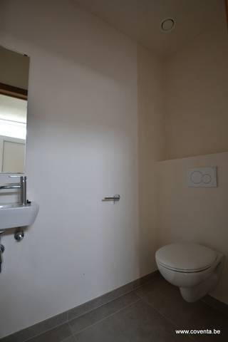 Deze nieuwbouwwoning bestaande uit: inkomhal met toilet, lichtrijke woonkamer - salon met aansluitende ingerichte keuken en berging/wasplaats.Op de...