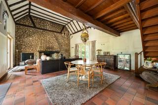 <p><span>Gelegen in een rustige, doodlopende straat bevindt zich deze te renoveren villa op een ruim perceel van ca. 1.753 m². Dankzij de groene omgeving en de nabijheid van het Antitankkanaal is dit de ideale woning voor wie houdt van rust, natuur en buitenleven.</span></p>
<h3><span>Indeling</span></h3>
<p><span>Via de inkomhal, voorzien van een gastentoilet met handenwasser en een vestiaire, betreedt u de woning. De ruime leefruimte met open haard vormt het hart van de woning. In het salon reikt het plafond tot in de nok, wat zorgt voor een uitzonderlijk gevoel van ruimte en licht.</span></p>
<p><span>Grote schuiframen bieden een mooi zicht op het terras en de tuin en zorgen voor een directe verbinding met buiten. Aansluitend bevindt zich de ingerichte keuken, eveneens met uitzicht op en toegang tot de tuin.</span></p>
<p><span>Verder beschikt de woning over een inpandige garage met automatische sectionaalpoort. Vanuit de garage is de kelder bereikbaar.</span></p>
<h3><span>Verdieping</span></h3>
<p><span>De overloop met vide, momenteel ingericht als bureauruimte, geeft toegang tot twee ruime slaapkamers. De hoofdslaapkamer beschikt over een praktische dressing.</span></p>
<p><span>Daarnaast zijn er twee badkamers, beide uitgerust met een lavabo, douche en toilet.</span></p>
<p><span>De bergzolder is bereikbaar via een uitschuifbare trap.</span></p>
<h3><span>Buitenruimte</span></h3>
<p><span>De volledig omheinde tuin biedt tal van mogelijkheden. Achteraan bevindt zich een paddock van ca. 1.000 m² met paardenstallen, ideaal voor paardenliefhebbers of het houden van dieren.</span></p>
<p><span>Dankzij de ligging vlak bij het Antitankkanaal geniet u van een prachtige omgeving voor wandelingen, fietstochten en buitenactiviteiten.</span></p>
<h3><span>Bijzonderheden</span></h3>
<ul>
<li><span>Rustige ligging in een doodlopende straat</span></li>
<li><span>Perceel van ca. 1.753 m²</span></li>
<li><span>Houten raamwerk met dubbele en deels enkele beglazing</span></li>
<li><span>Kelder en kruipkelder</span></li>
<li><span>Verwarming op aardgas (condensatieketel uit 2022)</span></li>
<li><span>EPC: 382 kWh/m²/jaar</span></li>
<li><span>UC: 3910607</span></li>
<li><span>Stedenbouwkundige inlichtingen: Vg – Wg – Gvv – Gvkr – Gmo – Gworg</span></li>
</ul>