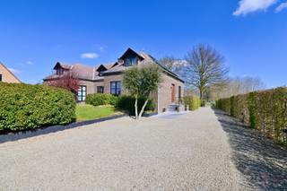 Deze prachtig gerenoveerde halfopen bebouwing in Alken, gelegen op de Hoogsimsestraat, bevindt zich op een ruim perceel van maar liefst 1ha39a60ca en biedt een unieke kans voor paarden- en dierenliefhebbers die comfortabel willen wonen in een groene, en rustige omgeving, doch vlakbij het N80 richting Sint-Truiden en Hasselt, alsook het centrum van Alken.<br /><br />Sinds 2018 werd de woning grondig en smaakvol gerenoveerd, met bijzondere aandacht voor energiezuinigheid en modern wooncomfort. Zo geniet u onder andere van hoogrendementsbeglazing, een recente verwarmingsketel op aardgas, airconditioning boven &amp; beneden en vernieuwde badkamers en vloeren – instapklaar en zorgeloos wonen gegarandeerd.<br /><br />Bij het betreden van de woning wordt u verwelkomd in een ruime inkomhal met open trap, gastentoilet en een praktische vestiaire-/bureauhoek. De lichtrijke leefruimte vormt het hart van de woning en combineert moeiteloos een gezellige zithoek, eetruimte en speelhoek/werkplek. Grote raampartijen zorgen hier voor een aangename connectie met buiten. De volledig vernieuwde en uitgeruste keuken is een echte troef en beschikt over kwalitatieve toestellen zoals een heteluchtoven (BAUKNECHT), inductiekookplaat (SIEMENS), dampkap (NOVY) en vaatwasser (BOSCH), afgewerkt met een stijlvol composiet werkblad inclusief spoelbak. Vanuit de keuken en van aan de ontbijttafel, geniet u van een prachtig uitzicht op de tuin, het terras en de omliggende weilanden. Het aansluitende verhoogde terras met hetzelfde mooie zicht, is de ideale plek om te ontspannen.<br /><br />De bovenverdieping biedt drie volwaardige slaapkamers, een dressing en een moderne badkamer uitgerust met bad, dubbele lavabo en toilet – perfect voor het hele gezin.<br /><br />Op de benedenverdieping vindt u een centrale hal met toegang tot een voorraadkelder, vernieuwde douchekamer (met ingebouwde wasvoorzieningen) en een ruime garage met werkplaats, die plaats biedt aan een wagen, fietsen en extra opslag.<br /><br />Ook buiten is het puur genieten. De fraai aangelegde tuin, aangelegd in samenspraak met een tuinarchitect, beschikt over een grote oprit tot aan de weilanden en een afsluitbare toegangspoort voor optimale privacy. Extra troeven zijn de stalling met uitloop, speeltuin en uitgestrekte weilanden.<br /><br />Voor paardenliefhebbers is dit een absolute droom: een stalling met twee boxen, voederkamer en uitlooppaddock, gecombineerd met een weiland van meer dan 1 hectare – ideaal om uw dieren aan huis te houden.<br /><br />Bent u op zoek naar rust, ruimte en luxe gecombineerd met dierenmogelijkheden? Dan is dit een unieke opportuniteit die u niet mag missen. Bel ons snel op 011 70 70 19.