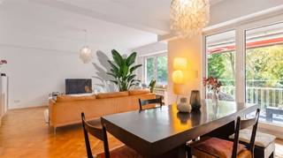 Located in a prime spot next to Antwerp’s Stadspark, this exceptionally elegant apartment is situated on the first floor of the charming Residence Longchamps. It offers a unique blend of grandeur, authentic details, refined design, and modern comfort.The sunny front terrace offers a beautiful, green view of the City Park and is one of the property’s greatest assets. Inside, the oak herringbone parquet flooring, original radiator cabinets with brass grilles, and restored wardrobes create a timeless ambiance. An authentic hatch from the former service elevator serves as a special piece of history.The stylish Boffi kitchen features a natural stone countertop and high-quality Gaggenau appliances, complemented by a Bosch American-style refrigerator and an integrated dishwasher. Adjacent to the kitchen are a storage room with a balcony and a separate laundry room.The hallway leads to three bedrooms, a walk-in closet, a guest restroom, and a bathroom. The master bedroom is situated in a quiet spot at the rear and has its own terrace and direct access to the bathroom. The second bedroom charms with its French-style built-in closet doors.The apartment also features a private attic room and a basement storage unit.Residence Longchamps dates back to 1957 and exudes the elegant atmosphere of Antwerp’s bygone era. A rare urban residence for those who appreciate authenticity, design, space, and an exceptional location.