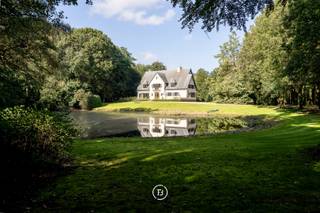 On an expansive 10-hectare estate, bordered by a historic tree-lined lane and green surroundings, lies a characterful property with numerous possibilities. The residence exudes elegance and has been largely refreshed, preserving its original style.<br /><br />Inside, you are welcomed by a spacious entrance hall with staircase, guest toilet and cloakroom, a dining room, and a cosy lounge with wood panelling overlooking the garden. The kitchen with breakfast area connects seamlessly and adjoins a separate wing currently set up as a caretaker's residence. This wing includes a sitting area, kitchen, two bedrooms, and a bathroom on the upper floor. It can easily serve as staff quarters, guest accommodation, or an extension of the main house.<br /><br />The house is fully basemented, providing additional functional space for laundry, storage, and technical installations.<br /><br />Next to the main house stands a large outbuilding with room for six cars. The estate also features an orangerie, suitable for a variety of uses such as entertaining, a studio or hobby space. At the rear of the property, accessible via Rietstraat, is a charming hunting lodge with greenhouse and vegetable garden. This section of the estate, including the adjacent land, offers potential for subdivision.<br /><br />The outdoor layout is equally impressive: a pond graces the front of the house, while a large swimming pool with pool house at the rear offers space for relaxation. The surrounding meadows are particularly well-suited for animal lovers.<br /><br />The estate offers complete privacy in a green setting, with convenient access to the E40 via the Beernem exit.