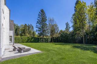 <section>
<div>
<div>
<div>
<div>
<div>
<div>
<p>In een prachtige residentiële wijk, met talrijke wandelpaden en natuur in de nabije omgeving, bevindt zich deze magnifieke villa op een royaal perceel van 2.415 m² met zuidgerichte tuin. De ligging biedt rust, privacy en wooncomfort, in een groene omgeving die uitnodigt tot wandelen en genieten.</p>
<p>Deze eigendom combineert uitzonderlijke volumes, hoogwaardige materialen en een bijzonder doordachte indeling. Al bij het betreden van de woning wordt u verwelkomd in een inkomhal met een hoogte van maar liefst 6,40 m. Het gevoel van licht, openheid en grandeur is hier meteen aanwezig. Het gelijkvloers heeft hoge plafonds van 3,20 m, massief eiken binnendeuren (2,50 m hoog) en een verfijnde afwerking met parketvloeren, gecombineerd met natuursteen.</p>
<p>De leefruimtes zijn royaal, lichtrijk en praktisch ingedeeld. Het gelijkvloers omvat een bureel, een tv-kamer, een woonkamer met open haard, een keukenruimte eveneens voorzien van open haard, een volledig ingerichte bijkeuken en een inpandige garage voor twee wagens. De verschillende ruimtes sluiten logisch op elkaar aan en creëren een aangename woonflow.</p>
<p>De woning is reeds afgewerkt met kwalitatieve materialen, met uitzondering van het keukeneiland en de badkamers. Deze kunnen door de koper nog volledig naar eigen smaak worden geïnstalleerd. Hierdoor vormt deze villa een blank canvas: een hoogwaardige en stijlvolle basis, met ruimte voor persoonlijke keuzes in de verdere afwerking.</p>
<p>Op de eerste verdieping bevinden zich meerdere slaapkamers, een royale mastersuite met dressing en badkamer, een wasplaats en een tweede badkamer. De zolderverdieping biedt bijkomende volwaardige kamers, een nachthal en technische ruimte.</p>
<p>Een uitzonderlijke villa met uitstraling, kwaliteit en toekomstwaarde.</p>
</div>
</div>
</div>
</div>
</div>
</div>
</section>