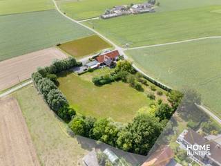 Te midden van de uitgestrekte velden bevindt zich deze uitzonderlijke eigendom waar rust en luxe samenkomen op een perceel van 11.187m². Dit historisch landgoed werd met oog voor detail gerenoveerd tot een instapklare parel, waar de combinatie van authentiek karakter en moderne architectuur zorgt voor een unieke woon- en belevingservaring. Dankzij de succesvolle B&B, de aanpalende herberg en de luxueuze privéwoning biedt dit domein bovendien een interessante opportuniteit voor wie op zoek is naar een levensproject met rendement. Het eigendom wordt beschouwt als "Handelshuis"<br /><br />De hoofdwoning charmeert met hoge plafonds, overvloedige glaspartijen en een lichtrijke leefruimte met zicht op de uitgestrekte tuin. De leefruimte sluit naadloos aan op een volledig uitgeruste keuken met keukeneiland. Een mezzanine met zicht op de tuin fungeert als bureau of hobbyruimte. De woning telt zes slaapkamers, waarvan vijf momenteel worden uitgebaat als volwaardige B&B-kamers met elk een eigen badkamer en toiletvoorziening. De master bedroom beschikt over een aparte dressing en een privé badkamer.<br /><br />Daarnaast is er een volledig uitgeruste wellnessruimte met hammam, infraroodsauna en jacuzzi en een ruim zonneterras dat grenst aan de perfect onderhouden tuin. De aanpalende herberg straalt authenticiteit uit en leent zich uitstekend voor evenementen of een horecazaak in combinatie met het gastenverblijf. <br /><br />Op technisch vlak is het geheel tot in de puntjes afgewerkt: vloerverwarming is per kamer regelbaar, het energieverbruik is optimaal dankzij een EPC-label A, 83 zonnepanelen, ongeveer 40 kW aan batterijopslag en een geothermische warmtepomp. Een ruime garage van 98 m² en zes extra parkeerplaatsen maken het eigendom compleet.<br /><br />Een uitzonderlijke eigendom die moeiteloos wonen en visie op de toekomst combineert — en dat alles in een groene omgeving.<br /><br />Contacteer ons nu voor een plaatsbezoek en ontdek zelf de charme van dit exclusieve eigendom!