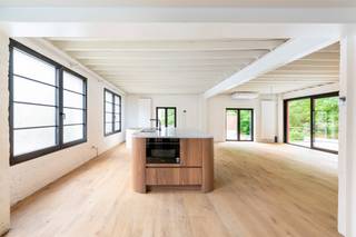<p><strong><span>Achter deze discrete gevel schuilt één van de meest unieke loftwoningen van Mortsel.</span></strong></p>
<p><span>Sommige eigendommen zijn meer dan een woning. Ze vertellen een verhaal. Deze voormalige potloodfabriek werd in 2025 met uitzonderlijk veel respect voor haar industriële verleden volledig gerenoveerd tot een exclusieve loft van maar liefst </span><strong><span>430 m²</span></strong><span>, waar authentieke charme, hoogwaardige afwerking en hedendaags comfort perfect samensmelten.</span></p>
<p><span>Via de private inrit bereikt u de binnenkoer, waar meerdere wagens op eigen terrein kunnen parkeren. Het gelijkvloers biedt een waaier aan mogelijkheden en is volledig polyvalent ingericht. De verschillende ruime vertrekken kunnen dienst doen als exclusieve garage voor oldtimers of sportwagens, atelier, showroom, praktijkruimte, kantoor of opslag. Dankzij de aparte douche en het afzonderlijke toilet is deze verdieping ook perfect geschikt voor een vrij beroep of een combinatie van wonen en werken. Vanuit het gelijkvloers heeft u bovendien rechtstreeks toegang tot de zonnige, volledig privatieve tuin, waar rust en privacy centraal staan.</span></p>
<p><span>Met de trap of de personen- en goederenlift bereikt u de indrukwekkende loft op de eerste verdieping. Hier zorgen de hoge plafonds, grote raampartijen en overvloedige lichtinval voor een uitzonderlijk gevoel van ruimte. De originele industriële elementen werden zorgvuldig behouden en gecombineerd met warme parketvloeren en kwalitatieve materialen, waardoor een stijlvolle en tijdloze woonomgeving ontstond.</span></p>
<p><span>Centraal in de leefruimte bevindt zich de exclusieve open maatwerkkeuken, uitgevoerd in warm hout met elegante afgeronde lijnen en afgewerkt met een luxueus marmeren werkblad. Hoogwaardige inbouwtoestellen, slimme opbergruimte en een doordachte indeling maken deze keuken tot het kloppende hart van de woning.</span></p>
<p><span>De loft beschikt momenteel over een royale master suite met een vrijstaand ligbad als echte blikvanger. Daarnaast is er een tweede stijlvolle badkamer met inloopdouche en toilet. Dankzij de royale oppervlakte kunnen, indien gewenst, eenvoudig meerdere extra slaapkamers worden gecreëerd zonder afbreuk te doen aan het unieke loftgevoel.</span></p>
<p><span>Deze eigendom combineert een karaktervolle industriële architectuur met hedendaags wooncomfort. Airconditioning, een personen- en goederenlift, hoogwaardige afwerkingen, parkeermogelijkheden en een gunstig EPC-label B maken het geheel compleet.<br /><br />Belangrijkste troeven:<br />-Voormalige potloodfabriek volledig gerenoveerd in 2025<br />-Circa 430 m² bruikbare oppervlakte<br />-Exclusieve loftwoning met authentieke industriële architectuur<br />-Hoogwaardige afwerking en kwaliteitsmaterialen<br />-Personen- en goederenlift<br />-Airconditioning<br />-Polyvalente gelijkvloerse verdieping voor vrij beroep, atelier, showroom, garage of praktijk<br />-Exclusieve maatwerkkeuken met marmeren werkblad<br />-Mogelijkheid tot meerdere slaapkamers<br />-Twee stijlvolle badkamers<br />-Zonnige, volledig privatieve tuin<br />-Meerdere parkeerplaatsen op eigen terrein<br />-EPC-label B<br /></span></p>
<p><span>Een uitzonderlijke eigendom voor wie op zoek is naar ruimte, karakter en flexibiliteit. Of u nu droomt van een exclusieve loftwoning, een inspirerende werkplek of een combinatie van beide, deze unieke voormalige potloodfabriek biedt een woonbeleving die zelden op de markt verschijnt.</span></p>
