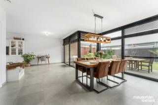 Looking for a spacious, recently built (2022) and energy-efficient home? This move-in ready family house offers an impressive 229 m² of living space on a 325 m² plot, combining modern comfort with a practical layout.<br /><br />Upon entering, you are welcomed into an entrance hall with a guest toilet, leading to the bright living area featuring large windows.<br /><br />The living space seamlessly flows into the open kitchen with a stylish island. The kitchen forms the heart of the home, providing plenty of space for family moments and entertaining friends.<br /><br />Adjacent to the kitchen is a spacious laundry/storage room, perfect for extra storage and keeping the household organized.<br /><br />The house includes four full-sized bedrooms, including a master bedroom with its own dressing room. Additionally, there are two comfortable bathrooms, ensuring optimal comfort for the whole family.<br /><br />A major asset is the very spacious attic with a fixed staircase, offering numerous possibilities as a hobby room, additional storage, or future expansion.<br /><br />Outside, enjoy a pleasant garden with a partially covered terrace, ideal for relaxing in every season. The property also features a carport with an outdoor storage room and ample parking space for three cars on the premises.<br /><br />Technically, this home scores exceptionally well:<br />• Certified electrical installation<br />• High-quality finishes<br />• 8 solar panels<br />• Asbestos-free<br />• Highly energy-efficient (Nearly Zero-Energy Building – E29 – energy label A)<br />• 10,000-liter rainwater tank<br /><br />In short, a spacious and impeccably maintained home offering all the comfort, energy efficiency, and space a modern family could wish for.