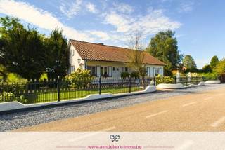 Op zoek naar een plek waar rust, ruimte en natuur samenkomen?<br />Deze charmante vrijstaande woning uit 1988 ligt in een landelijke omgeving aan een rustige weg en biedt een prachtig uitzicht over de achterliggende natuur en het water. Met een perceel van 730 m² geniet je hier van privacy en een idyllische ligging.<br /><br />Woongelegenheid is voorzien over drie verdiepingen, telkens met een doordachte indeling en voldoende wooncomfort:<br /><br />- Gelijkvloers<br />Een inkomhal leidt je naar de lichtrijke woonkamer met zicht op het groen. De keuken sluit aan op de gezellige veranda, ideaal voor gezellige momenten. Verder vind je hier twee ruime slaapkamers en een badkamer met bad én douche.<br /><br />- Benedenverdieping <br />Een volwaardige leefruimte met keuken, zithoek, slaapkamer, wasplaats en badkamer. Vanuit de zithoek stap je rechtstreeks naar het terras met uitzicht op de tuin en het water. Daarnaast zijn er nog praktische berg- en technische ruimtes aanwezig.<br /><br />- Bovenverdieping: <br />Twee ruime slaapkamers en een royale overloop. De ramen in beide kamers zorgen voor voldoende lichtinval en bieden een prachtig uitzicht op de tuin en het water.<br /><br />Buiten is het volop genieten in de groene tuin aan het water. Het vrije uitzicht en de landelijke ligging creëren een oase van rust, terwijl alle dagelijkse voorzieningen in het nabije dorp gemakkelijk bereikbaar zijn.<br />Kortom: een unieke kans voor wie houdt van ruimte, rust en natuur!
