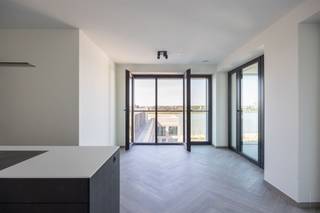 <p><span>Hoogwaardig nieuwbouwappartement met winter- en zomerterras en fenomenaal zicht op de Schelde !</span></p><p><span>Sommige appartementen bieden comfort. Andere bieden een mooi uitzicht. En dan zijn er appartementen waar hoogwaardige materialen, ruimte en buitenleven perfect samenkomen.</span></p><p><span>Welkom in dit prachtige 2-slaapkamerappartement op de 7de verdieping aan de Frans Buyensstraat 15, gelegen in het gegeerde Scheldehof in Nieuw Zuid. Het project werd ontworpen door de internationaal gerenommeerde architect Max Dudler en is opgevat als een harmonisch geheel dat de stad, het landschap en de Schelde met elkaar verbindt.</span></p><h3><span>Wonen aan de Schelde</span></h3><p><span>Residentie Scheldehof combineert rustig wonen met een uitgesproken stedelijke omgeving. De gebouwen zijn naar de Schelde gericht, waardoor vanuit verschillende appartementen en gemeenschappelijke ruimtes weidse vergezichten ontstaan.</span></p><p><span>Ook groen speelt hier een belangrijke rol. Centraal bevindt zich een ruime binnentuin, ontworpen door Bureau Bas Smets, terwijl de terrassen en gaanderijen het buitenleven als vanzelf onderdeel maken van het wonen. Daarnaast kunnen bewoners gebruikmaken van een riant collectief dakterras.</span></p><p><span>Vanuit dit appartement geniet u van een fenomenaal uitzicht over de Schelde. Met een EPC-label A en driedubbele beglazing in aluminium combineert de woning dit uitzicht bovendien met hedendaags en energiezuinig wooncomfort.</span></p><h3><span>Indeling</span></h3><p><span>Met de lift bereikt u de 7de verdieping. De inkomhal verbindt alle ruimtes en is afgewerkt met een stijlvolle visgraat parkettegel, die zorgt voor een warme en elegante uitstraling.</span></p><p><span>Via de stijlvolle gietijzeren deur betreedt u de ruime leefruimte. Dankzij de grote raampartijen valt het natuurlijke licht rijkelijk binnen en trekt het indrukwekkende uitzicht over de Schelde meteen de aandacht.</span></p><p><span>De leefruimte biedt voldoende plaats voor een royale zithoek en eettafel. Aansluitend bevindt zich de open eilandkeuken oorzien van een composiet werkblad en marmeren spoelbak, passend binnen de hoogwaardige uitstraling van het appartement die gedeeltelijk is afgewerkt.</span></p><p><span>Vanuit de leefruimte heeft u rechtstreeks toegang tot zowel het winter- als zomerterras. Beide terrassen vormen een mooie verlenging van de leefruimte en kunnen volledig naar eigen smaak worden ingericht. Het winterterras leent zich bijvoorbeeld uitstekend als gezellige leeshoek of extra zithoek, waar u het hele jaar door kunt genieten van het indrukwekkende Scheldezicht.</span></p><p><span>Verder beschikt het appartement over twee slaapkamers.</span></p><p><span>De badkamer is bijzonder hoogwaardig afgewerkt en volledig uitgevoerd in marmer, met een ruime inloopdouche en lavabo. Ook het aparte toilet werd volledig in marmer afgewerkt en vormt een stijlvol detail.</span></p><p><span>Daarnaast is er een ruime technische berging met voldoende plaats voor zowel wasmachine als droogkast.</span></p><p><span>Ondergronds kan een autostaanplaats optioneel worden aangekocht voor een vraagprijs van 40.000 euro.</span></p><h3><span>Troeven</span></h3><ul><li><span>Ruim winter- én zomerterras</span></li><li><span>Fenomenaal zicht over de Schelde</span></li><li><span>EPC-label A</span></li><li><span>Driedubbele beglazing in aluminium</span></li><li><span>Hoogwaardige en luxueuze afwerking</span></li><li><span>Volledig marmeren badkamer en toilet</span></li><li><span>Open eilandkeuken met composiet werkblad en marmeren spoelbak</span></li><li><span>Groene binnentuin ontworpen door Bureau Bas Smets</span></li><li><span>Absolute toplocatie in Nieuw Zuid</span></li></ul><p><span>Een bijzonder appartement waar hoogwaardige afwerking, energiezuinig comfort, buitenruimte en een uniek Scheldezicht samenkomen. Een woning die u vooral zelf moet ervaren.</span></p>