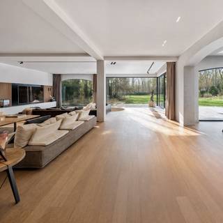 <p>Quares - TREVI Groep presenteert :<br />Voor deze knappe eigendom klinken superlatieven te bescheiden. Het is werkelijk indrukwekkend, fenomenaal, magnifiek! Voor wie houdt van discretie, rust, luxe en privacy.</p>
<p>Na een 70m lange oprijlaan verschijnt een elegante gevel die je onmiddellijk doet dromen: je waant je in de Hamptons, New York. De recent vernieuwde gevelbekleding doet de woning schitteren in haar nieuwe jasje. Een lang bordes nodigt je uit om de woning te ontdekken.</p>
<p>Binnen kijk je je ogen uit in de royale inkomhal met keizerlijke trap, die naar de bibliotheek en slaapvertrekken leidt.</p>
<p>GELIJKVLOERS:</p>
<p>In de rechtervleugel bevinden zich de dubbele garage met berging, vestiaire, en de logeerkamer met en suite gastenbadkamer.</p>
<p>In de linkervleugel ligt de bureauruimte waar het rustig werken is, en die ruim genoeg is om klanten op aangename wijze te ontvangen; en een gastentoilet.</p>
<p>Aan de achterzijde bevindt zich de gigantische leefruimte met keuken: het kloppende hart van de woning, met een adembenemend zicht op de tuin.</p>
<p>Dit deel is bijzonder stijlvol vernieuwd, met een hedendaagse look &amp; feel en hoogwaardige materialen. Een grote gashaard, gezellige zitput, gimmicks zoals een verdwijnend raam en doorkijk naar de keuken, maken dat deze ruimte op verschillende momenten van de dag anders aanvoelt. Het grote panoramische raam is als een landschapsschilderij, maar dan van de eigen tuin. De keuken is volledig geëquipeerd en wordt geflankeerd door een enorm overdekt terras, waardoor het binnen-buitengevoel compleet is. Dit is een woning waar je kan genieten, en je graag veel tijd in wil doorbrengen.</p>
<p>VERDIEPING:</p>
<p>Linkervleugel: hier bevindt zich de grootste badkamer, een behoorlijk futuristisch ontwerp met centraal element waarrond de verschillende functies zich bevinden: ruime douche, hoekbad, dubbele lavabo, omkleedhoek. Aansluitend bevindt zich een praktische wasplaats, strijkruimte en apart toilet.</p>
<p>Een dressing leidt naar de comfortabel ruime master bedroom met zicht op de tuin, die naar een tweede open dressing of extra slaapkamer leidt. Ernaast bevindt zich een fitnessruimte die een derde slaapkamer kan zijn.<br /><br />In de rechtervleugel bevinden zich 2 prachtige ruime slaapkamers met mezzanine - een droom voor vele tieners – en een derde badkamer met ligbad en douche completeert het geheel.</p>
<p>Samen komen we op 6 slaapkamers in het totaal, 5 boven en 1 beneden, plus een dressing boven en bureau beneden. Ideaal voor wie ruim wil wonen, samengesteld gezin, werken &amp; wonen, B&amp;B en wonen, etc.</p>
<p>KELDER</p>
<p>Uiterst praktisch is de enorme kelder die deels verwarmd is, met hobbyruimtes, wijnkelder en opslagruimtes. Verder is er nog een kruipkelder.</p>
<p>TUIN:</p>
<p>In de tuin aansluitend aan de oprit, bevindt zich een bijgebouw met aparte fietsenberging, berging voor alle tuinonderhoudsmaterialen, en ruimte voor sport en ultieme ontspanning: een zwemspa met jetstream &amp; onderwaterloopband, en een heerlijke jacuzzi. Wellness in eigen tuin. De tuin zelf is een prachtig glooiend gazon met zuid-zuidwest oriëntatie, omzoomd met struiken, bloemen en grote bomen. Mooi aangelegd èn beperkt in onderhoud zodat je er ook echt van kan genieten.</p>
<p>Halverwege de tuin loopt het hoofdperceel over in 2 percelen bouwgrond (85B en 85C op het bijgevoegde plan), die mee aangekocht kunnen worden aan respectievelijk 300.000EU en 325.000EU, maar die niet allebei absoluut noodzakelijk zijn om het weidse aspect te behouden.</p>
<p>Technisch is deze woning uitgerust met warmtepompen, airco, dak- en muurisolatie, hoogrendementsglas, alarm en camera’s, domotica, een conforme state-of-the-art elektrische installatie, en mèt een EPC A, wat zeer uitzonderlijk is voor dit type woning en uiteraard een enorme troef!</p>
<p>Geïnspireerd en klaar om deze droomwoning te ontdekken? Maak dan een afspraak met Tinne op 0477 60 21 99 of tinne.schotsmans@quares.be</p>
