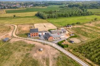 EERSTE BEZOEKDAG DINSDAG 25/8 VAN 16u00 TOT 19u00 (enkel op afspraak!)<br /><br />ASSE – Instapklare woning met stallen op ca. 1,8 ha en mogelijkheid tot aankoop van bijkomende grond<br /><br />In het landelijke Asse bevindt zich deze instapklare eigendom die wonen en ruimte op een unieke manier combineert. Deze zonevreemde woning is gelegen op een perceel van ongeveer 1,8 hectare en biedt bovendien de mogelijkheid om nog eens 2,1 hectare aangrenzende grond bij aan te kopen. Hierdoor is dit een uitgelezen kans voor paardenliefhebbers of dierenhouders die op zoek zijn naar een eigendom met tal van mogelijkheden.<br /><br />Op het gelijkvloers beschikt de woning over een inkomhal, een gezellige leefkeuken, een lichtrijke woonkamer en een apart gastentoilet. De eerste verdieping omvat drie volwaardige slaapkamers, een praktische berging en een badkamer. Op de tweede verdieping bevinden zich nog twee extra slaapkamers die perfect kunnen dienen als kinder-, hobby- of bureauruimte.<br /><br />Aansluitend aan de woning bevinden zich een garage en een polyvalente ruimte die flexibel kan worden ingericht volgens uw eigen noden. Het ruime bijgebouw is uitgerust met tien stallen, zadelkamer en een wasplaats, waardoor deze eigendom zich uitstekend leent voor het houden van paarden of een andere (para)-agrarische activiteit.<br /><br />Dankzij de combinatie van een instapklare woning, een uitgebreide infrastructuur en een royaal perceel vormt deze eigendom een zeldzame opportuniteit voor wie comfortabel wil wonen in een groene omgeving met alle ruimte.<br /><br />Wenst u meer informatie over deze eigendom of wilt u graag een bezoek inplannen? Aarzel dan niet om ons te contacteren via 053/60.65.66.