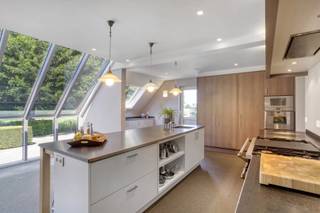 Zeer nette gezinswoning met 4 slaapkamers in een rustige doodlopende straat op een perceel van 1312m², bestaande uit 2 bouwgronden
INDELING
Gelijkvloers
De ruime inkomhal met gastentoilet (17m²) geeft toegang tot de lichtrijke leefruimte bestaande (42m²) uit een zit- en eethoek. Via de glazen deur komt men vervolgens in de grote en prachtige, professioneel uitgeruste keuken die baadt in het licht dankzij de grote ramen die voorzien zijn van elektrische screens. De keuken (34m²) bestaande uit 2 aparte zones beschikt o.m. over een amerikaanse koelkast, een professionele supersnelle vaatwasser, een steamer en microgolf en gril (Gagenau). Via een schuifdeur kan men de kelder betreden en ook de voomalige garage die momenteel is ingericht als werkruimte (23m²) met daarin vele maatkasten en ook plaats voor een wasmachine en droogkast.
Verdieping
Hier bevinden zich 4 slaapkamers (17m² - 16m² - 15m²- 12m²) en de badkamer (12m²) met daarin een toilet, bad, douche en dubbel lavabomeubel met maatkasten.
Kelder/zolder
De woning heeft een ruime droge kelder (30m²) en is verder volledig onderkelderd. De zolder is bereikbaar via een vliertrap en kan dienst doen als bergruimte.
Tuin
In de tuin is er achteraan een bijgebouw (77m²) dat bestaat uit een garage en werkplaats. Hier is ook krachtstroom en een alarm voorzien. Verder staat er 2e bijgebouw (60m²) aan de straatzijde (op het 2e perceel grond) bestaande uit dubbele carport (36m²) berging (12m²) en overdekt terras (12m²) met daarin een buitenkeuken.
Tenslotte is er ook een mooie serre.
BIJZONDERHEDEN
gunstig EPC C (269 Kwh/m²/j);  verwarming op stookolie; aansluiting gas is al voorzien; alarm in woning en bijgebouw; waterontharder; waterput; achterzijde perceel ligt in agrarisch gebied
POSITIEVE ASPECTEN
zeer nette, verzorgde woning;   veel lichtinval; mooie tuin;  prima ligging, in rustige verkaveling nabij het centrum en op het einde van een doodlopende straat; unieke keuken; asbestveilig
Stedenbouwk. inlichtingen in aanvraag