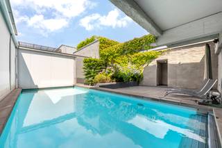 <p>Situé dans le quartier central et animé d'Anvers Zurenborg, cet immeuble unique offre une expérience de vie exceptionnelle dans un bâtiment isolé avec parking. La propriété dispose d'équipements de luxe tels qu'une piscine et un sauna, entourés de verdure, et dispose d'une entrée privée et d'un ascenseur privé.</p>
<p>L'appartement comprend deux chambres spacieuses et deux salles de bains. La suite parentale offre une vue magnifique depuis la terrasse et dispose d'une salle de bains luxueuse avec baignoire, lavabos individuels avec éclairage LED, douche spacieuse avec carrelage luxueux et dressing supplémentaire pour un espace de rangement optimal. La deuxième chambre dispose de sa propre salle de bains, ce qui offre un confort et une intimité supplémentaires.</p>
<p>La cuisine est en excellent état et est équipée d'un immense îlot central comprenant un évier et une plaque de cuisson, entouré de placards spacieux et de branchements. Cet espace est directement adjacent à un jardin et à une terrasse avec des portes coulissantes, ce qui crée une transition harmonieuse entre l'intérieur et l'extérieur. La salle à manger est située à côté de l'îlot de cuisine, ce qui confère une sensation d'ouverture et d'espace à l'ensemble de la surface habitable.</p>
<p>L'appartement offre deux grandes pièces qui peuvent être aménagées de manière flexible en salon, bureau ou une combinaison des deux, selon vos besoins. Le salon est un espace ouvert et artistique, très lumineux et doté d'une cheminée agréable.</p>
<p>Avec ses nombreux rangements grâce à ses grandes armoires encastrées, ce bien offre non seulement luxe et confort, mais aussi fonctionnalité.</p>