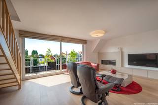 <p>Dans cette belle résidence à taille humaine, construite en 2014, nous vous proposons à la vente un spacieux appartement duplex comprenant <strong>3 chambres à coucher à part entière, 2 salles de bains et 2 terrasses</strong>. Possibilité d’acquérir un <strong>bon box de garage au rez-de-chaussée de la résidence</strong>.<span></span></p>
<p>L’appartement bénéficie d’une situation idéale, à proximité de <strong>Duinenwater</strong>, ainsi que du centre-ville et de la <strong>Lippenslaan</strong>. La gare et toutes les commodités se trouvent également à distance de marche.</p>
<p>L’entrée, avec toilette invités et vestiaire, donne accès au <strong>séjour spacieux et lumineux</strong>, orienté sud-ouest, agrémenté d’une agréable cheminée au gaz et donnant sur une belle terrasse avec <strong>vue dégagée</strong>. Toutes les pièces sont équipées de vitrages insonorisants et les chambres sont dotées de volets roulants insonorisants.</p>
<p>La <strong>cuisine moderne et ouverte</strong>, accompagnée d’une grande buanderie, donne accès à une deuxième terrasse, orientée sud-est, où vous pourrez profiter du <strong>soleil matinal</strong>.</p>
<p>À l’étage se trouvent <strong>3 chambres à coucher à part entière</strong>, toutes équipées de placards encastrés et de lits doubles. Les chambres disposent également de la climatisation. Le hall de nuit comprend une toilette séparée ainsi qu’une <strong>spacieuse salle de bains avec baignoire et douche</strong>. La chambre parentale bénéficie de sa <strong>propre salle de douche</strong>.</p>
<p>L’appartement dispose en outre de <strong>2 caves privatives</strong> ainsi que d’un débarras au rez-de-chaussée avec espace pour les vélos. Possibilité d’acquérir/louer un <strong>bon box de garage dans la résidence au prix de 85.000 €</strong>.</p>
<p><strong>Les meubles, rideaux et luminaires sont inclus dans le prix. Bon emplacement pour vélos</strong></p>