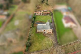 <p>Bent u op zoek naar een te renoveren woning of bouwgrond met tal van mogelijkheden, gelegen op een groot perceel en met een vlotte bereikbaarheid? Dan is dit eigendom beslist een bezoekje waard. De woning is steeds goed onderhouden en biedt royale volumes, 4 slaapkamers en een aangename tuin met prachtig uitzicht. Houd er rekening mee dat de woning dient gerenoveerd te worden en onder de <strong>renovatieplicht</strong> valt: binnen de 6 jaar na aankoop dient zij energetisch gerenoveerd te worden tot minstens een <strong>EPC-score D</strong>. Een ideale opportuniteit voor wie wil wonen in een groene omgeving met alle rust en privacy.</p>
<p><strong>GELIJKVLOERS</strong><br />U betreedt de woning via een ruime inkomhal van 10 m² op tegel. Ook via een achteringang van 5 m² heeft u bijkomende toegang.<br />De woonkamer van 42 m² op tegel is uitgerust met een pelletkachel.<br />Aansluitend bevindt zich een veranda van 23 m² op tegel waar u kan genieten van een wijds uitzicht.<br />De keuken van 20 m² is volledig uitgerust met inductieplaat, koelkast, vaatwasser, microgolfoven, heteluchtoven, dampkap, dubbele spoelbak en een praktische koffiecorner.<br />Verder vindt u op het gelijkvloers een wasplaats met douchekamer van 16 m², een bureel van 9 m² en een garage van 32 m² met automatische toegangspoort.</p>
<p><strong>TUIN EN BUITENRUIMTE</strong><br />De woning beschikt over een <strong>uitzonderlijk grote</strong> tuin met vijver, ideaal om in alle rust te genieten van het buitenleven.<br />Daarnaast is er een duivenhok met een oppervlakte van 40 m², dat ook andere invullingen kan krijgen.</p>
<p><strong>KELDER / KRUIPRUIMTE</strong><br />Praktische kelder- en kruipruimte van 17 m² op tegel, ingericht als bergkelder en technische ruimte.</p>
<p><strong>1STE VERDIEPING</strong><br />Op de eerste verdieping bevindt zich een overloop van 7 m² die toegang geeft tot drie volwaardige slaapkamers van respectievelijk 15 m², 16 m² en 13 m², allen afgewerkt met vinyl.<br />De badkamer van 8 m² is voorzien van een ligbad, enkele lavabo en toilet.</p>
<p><strong>2DE VERDIEPING</strong><br />De tweede verdieping omvat een overloop van 5 m² op vast tapijt, een vierde slaapkamer van 24 m², een berging van 8 m² en een extra zolderruimte van 20 m². Deze verdieping biedt bijkomend uitbreidingspotentieel.</p>
<p><strong>BIJZONDERHEDEN</strong><br />CV op mazout met ondergrondse stookolietank, thermostatische kranen, geboorde waterput (90 m diep), regenwaterput met inhoud 2.000 liter), automatische toegangspoort, dubbele beglazing, rolluiken, videofoon.</p>
<p><strong>POSTIEVE PUNTEN<br /></strong>Weids uitzicht<br />Veel parkeergelegenheid<br />Nabij invalswegen en autosnelwegen<br />Vier slaapkamers en twee badkamers<br />Grote, functionele ruimtes met enorm potentieel</p>