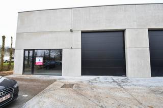 Loods te huur in het industriepark SCHATTING - De loods is voorzien van een sectionaal automatische poort en een inkomdeur met groot raam...