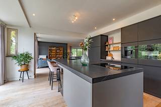 <strong>Ruime villa gebouwd in 2003 gelegen in een rustige wijk te Poppel op een perceel van ca. 1.192m² . De villa biedt u o.a. 3 slaapkamers, 3 badkamers en gezellige leefruimtes met een luxe woonkeuken met kookeiland. Een grote zolder met mogelijkheid tot 2 extra kamers en een dubbele inpandige garage met veel bergruimte. De aangelegde tuin biedt veel privacy en heeft een tuinoverkapping.<br />Gunstige ligging in een groene omgeving nabij de Nederlandse grens. EPC: B inclusief zonnepanelen.</strong><br /><br /><span>Gelijkvloers</span><br />U betreedt de woning via de riante inkomhal met gastentoilet en toegang tot de gezellig ingerichte woonkamer, voorzien van parketvloer en houtkachel. De aangrenzende open keuken is het hart van het huis en is recent vernieuwd. De keuken is o.a. voorzien van een kookeiland met bora inductiekookplaat met afzuiging, een Quooker, koelkast,diepvries, magnetron, oven en vaatwasser. ( allen Siemens) Bij de achteringang bevindt zich de bijkeuken met aansluiting voor wasmachine en droger, extra bergruimte en toegang tot de dubbele inpandige garage met smeerput.<br />Via een luik is er toegang tot een ruime bergzolder.<br /><br /><span>Eerste verdieping</span><br />De royale trap in de inkomhal brengt u naar de eerste verdieping. Hier bevinden zich 3 ruime slaapkamers . De masterbedroom heeft een eigen dressing, een badkamer voorzien van dubbele wastafel en ligbad/douche combinatie en een ruim balkon met zicht op de tuin.<br />Op de gang bevindt zich nog een seperaat toilet en neen extra badkamer met regendouche en wastafel.<br /><br /><span>Tweede verdieping</span><br />De vaste houten trap brengt u naar de ruime tweede verdieping van circa 80m². Deze ruimte moet nog worden afgewerkt maar biedt de mogelijkheid om nog 2/3 extra (slaap) kamers te realiseren.<br /><br /><u>Buitengebeuren</u><br />In de modern aangelegde tuin komt u volledig tot rust en geniet u van de bloemrijke borders, kleine fruitboomgaard en er is veel privacy aangezien zich maar een zijde bebouwing bevindt. De tuin heeft een overdekt terras met aangrenzende schuur, gemaakt van massief eiken delen. De achtertuin is gelegen op het zuidoosten. Aan de voorzijde van de woning is er volop parkeerruimte op eigen terrein.<br /><br /><span>Bijzonderheden</span><br />- EPC B<br />- 12 zonnepanelen met batterij<br />- Gezellige leefruimtes, mogelijkheid tot 5-6 slaapkamers<br />- Rustige ligging nabij scholen/winkels en Nederlandse grens<br />- Centrale verwarming op aardgas met radiatoren<br />- Elektriciteit goedgekeurd<br /><br />Neem zeker al eens een kijkje in de woning via onze virtuele toer: https://tour.giraffe360.com/ba1bb35fc96140b4b205725fa2317fac/