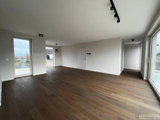 <h3>Indeling van het penthouse</h3>

<p>Dit stijlvolle nieuwbouwappartement biedt een <strong>lichtrijke leefruimte</strong> met directe toegang tot zowel het <strong>voor- als achterterras</strong>. Het achterterras is uitgerust met een zonneluifel en <strong>kijkt uit op het parkje</strong> achter het gebouw, wat zorgt voor een aangenaam en rustig uitzicht. De <strong>open keuken</strong> met eiland is volledig ingericht met moderne toestellen en sluit naadloos aan op de leefruimte. Verder is er een <strong>praktische wasplaats/berging</strong> en zijn er twee volwaardige slaapkamers aanwezig. De <strong>badkamer</strong> is uitgerust met een <strong>inloopdouche en een dubbel lavabomeubel</strong>, en er is een <strong>apart gastentoilet</strong> voorzien. Ondergronds beschikt het appartement over een <strong>autostaanplaats met een afgesloten berging</strong>. Dankzij de <strong>vloerverwarming</strong> en <strong>warmtepomp</strong> is het appartement bovendien bijzonder energiezuinig. Met een bewoonbare oppervlakte van 105 m² en 37 m² terrassen geniet je hier van een ruime woonbeleving. Het appartement werd <strong>volledig geschilderd en voorzien van lichtarmaturen</strong>, waardoor het instapklaar is.</p>

<h4>Praktisch</h4>

<ul>
	<li>Huurprijs: € 900 + € 50 autostaanplaats + € 50 syndic</li>
	<li>Onmiddellijk beschikbaar </li>
</ul>

<h4>Interesse? Vraag een bezoek aan</h4>
Vraag een bezoek aan via sarah@maesconceptimmo.be.