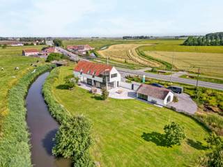 Wonen in alle rust, omringd door natuur en met een uitzicht dat elke dag opnieuw weet te verrassen? <br /><br />Deze stijlvolle villa biedt een uitzonderlijke woonbeleving op een indrukwekkend perceel van maar liefst 9.605 m². Vanuit de woning geniet u van een prachtig panoramisch zicht over de fraai aangelegde tuin, de achterliggende weilanden en de Blankenbergse Vaart, die als het ware door uw achtertuin stroomt.<br /><br />Via de inkomhal met vestiaire en gastentoilet betreedt u de lichtrijke leefruimte. Dankzij de grote raampartijen wordt het omliggende landschap hier maximaal naar binnen gebracht. Het weidse zicht over het groen zorgt voor een bijzonder gevoel van ruimte, rust en privacy.<br />De ruime keuken biedt voldoende plaats voor een grote eettafel en vormt een aangename plek om samen te komen. Aansluitend bevindt zich een praktische berging met aansluitingen voor wasmachine en droogkast, aangevuld met extra opslagruimte. Verder beschikt het gelijkvloers over een bureauruimte, ideaal voor thuiswerk, een vrij beroep, speelkamer,… Ook een technische berging is aanwezig.<br /><br />Op de verdieping bevindt zich de master bedroom met dressing en ensuite badkamer, voorzien van een douche. Daarnaast zijn er nog twee volwaardige slaapkamers en een tweede badkamer met douche. Een grote, open ruimte vormt hier een bijzonder veelzijdige extra troef. Deze kan naar wens worden ingericht als vierde slaapkamer, hobbyruimte, speelkamer, bureau of extra bergruimte. De aanwezige zolder zorgt bovendien voor nog meer praktische opbergruimte.<br />Op het perceel bevindt zich een afzonderlijk bijgebouw, momenteel ingericht als bureau. Dankzij de veelzijdige indelingsmogelijkheden kan deze ruimte perfect dienstdoen als atelier, praktijkruimte, hobbyruimte of thuiskantoor.<br /><br />U geniet hier van volledige rust, ruimte en privacy in een groene omgeving, terwijl winkels, scholen en andere dagelijkse voorzieningen zich op minder dan 5 km bevinden. Bovendien bevindt de villa zich op een strategische locatie tussen Brugge en de kust, waardoor zowel de stad als de zee vlot bereikbaar zijn.<br /><br />Een uitzonderlijke eigendom voor wie op zoek is naar ruimte, natuur, privacy en comfort, en daarbij elke dag wil genieten van een uniek uitzicht.<br /><br />Wenst u meer informatie of had u graag een bezoek gepland?<br />Contacteer Fleur via 0477 82 85 42 of fleur.beernaert@acasa.immo.