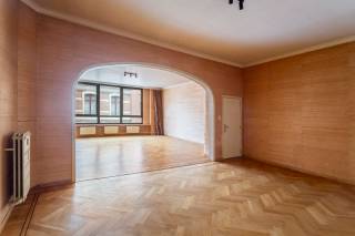 In het hart van de gegeerde Harmoniewijk bevindt zich dit karaktervolle appartement met terras en gemeenschappelijke tuin. Deze charmante buurt combineert een rustige, residentiële sfeer met een uitstekende bereikbaarheid en alle voorzieningen binnen handbereik. Op wandelafstand liggen het bruisende Zuid, de gezellige Markgravewijk en het Harmoniepark. <br /><br />Bij het betreden van de royale leefruimte vallen meteen de overvloedige lichtinval, de hoge plafonds en de indrukwekkende raampartijen op. De authentieke parketvloer en de sfeervolle open haard creëren een warme en uitnodigende sfeer. Aansluitend bevindt zich de volledig uitgeruste keuken, voorzien van een natuurstenen werkblad en tal van opbergmogelijkheden.<br /><br />Vanuit de leefruimte heeft u toegang tot het zonnige terras met uitzicht op de prachtige gemeenschappelijke tuin, een oase van rust midden in de stad. Op deze verdieping bevinden zich bovendien twee ruime slaapkamers en een badkamer.<br /><br />De derde en vierde kamer zijn ondergebracht op de tussenverdiepingen en bieden tal van mogelijkheden. Eén ruimte werd ingericht als bureau met eigen sanitair en wachtruimte, ideaal voor wie een professionele thuiswerkplek wenst. De tweede kamer beschikt over een eigen douchekamer en een aparte wasruimte.<br /><br />Kelderberging inbegrepen. Parking bij aan te kopen aan 20.000 EUR.<br />Kortom een unieke woonst met veel potentieel voor wie op zoek is naar ruimte, karakter en veelzijdigheid.<br /><br />Interesse? Contacteer LISTED voor een bezoek: +32 3 283 51 51.