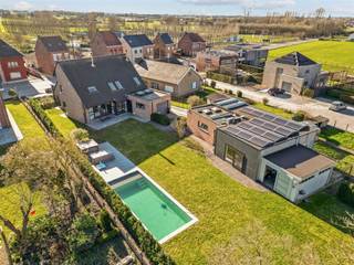 <p><span>Instapklare, </span><span>hoogwaardig afgewerkte woning</span><span> met </span><span>zwembad, poolhouse en multifunctioneel bijgebouw</span><span>, gelegen in een rustige en groene omgeving.</span></p><p><span>U wordt verwelkomd in een verzorgde inkomhal met ingemaakte vestiaire en een strakke, doorlopende tegelvloer die meteen de kwaliteitsvolle afwerking doorheen de woning benadrukt. Vooraan bevindt zich een </span><span>afzonderlijk bureau met maatkasten</span><span>, ideaal voor thuiswerk of een zelfstandige activiteit.</span></p><p><span>De leefruimte is </span><span>ruim, lichtrijk en perfect georiënteerd</span><span> met grote raampartijen en een schuifraam dat uitgeeft op terras en tuin. De gezellige haardcassette zorgt voor extra sfeer en comfort. Aansluitend vindt u de </span><span>moderne, volledig uitgeruste keuken met eiland</span><span>, voorzien van kwalitatieve toestellen, veel bergruimte en een directe connectie met de eetplaats en het buitenleven.</span></p><p><span>Op de verdieping beschikt de woning over </span><span>drie volwaardige slaapkamers</span><span> en een extra open ruimte die perfect kan dienen als </span><span>vierde slaapkamer, bureau of ontspanningsruimte</span><span>. De badkamer is compleet ingericht met </span><span>inloopdouche, ligbad en dubbele lavabo</span><span>. Daarnaast is er een apart toilet en extra bergruimte op de geïsoleerde zolder.</span></p><p><span>Technisch is deze woning volledig mee:<br /></span><span>zonnepanelen met batterij</span><span>, gunstig EPC, conforme elektriciteit, centrale verwarming op gas, alarmsysteem en waterverzachter.</span></p><p><span>Buiten wordt het plaatje compleet: een </span><span>onderhoudsvriendelijke tuin</span><span>, meerdere terrassen en een </span><span>prachtig zwembad met poolhouse </span><span> voorzien van keuken, airco en eigen sanitair (douche en toilet). Het </span><span>ruime bijgebouw (122m²)</span><span> met aparte techniekenruimte en kelder biedt tal van mogelijkheden: </span><span>praktijkruimte, fitness, atelier of hobbyruimte</span><span>.</span></p><p><span>Een </span><span>instapklare totaalwoning</span><span> waar comfort, ruimte en veelzijdigheid centraal staan ideaal voor wie wonen en werken wil combineren of gewoon op zoek is naar dat tikkeltje extra.</span></p>