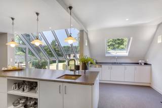 Zeer nette gezinswoning met 4 slaapkamers in een rustige doodlopende straat op een perceel van 1312m², bestaande uit 2 bouwgronden
INDELING
Gelijkvloers
De ruime inkomhal met gastentoilet (17m²) geeft toegang tot de lichtrijke leefruimte bestaande (42m²) uit een zit- en eethoek. Via de glazen deur komt men vervolgens in de grote en prachtige, professioneel uitgeruste keuken die baadt in het licht dankzij de grote ramen die voorzien zijn van elektrische screens. De keuken (34m²) bestaande uit 2 aparte zones beschikt o.m. over een amerikaanse koelkast, een professionele supersnelle vaatwasser, een steamer en microgolf en gril (Gagenau). Via een schuifdeur kan men de kelder betreden en ook de voomalige garage die momenteel is ingericht als werkruimte (23m²) met daarin vele maatkasten en ook plaats voor een wasmachine en droogkast.
Verdieping
Hier bevinden zich 4 slaapkamers (17m² - 16m² - 15m²- 12m²) en de badkamer (12m²) met daarin een toilet, bad, douche en dubbel lavabomeubel met maatkasten.
Kelder/zolder
De woning heeft een ruime droge kelder (30m²) en is verder volledig onderkelderd. De zolder is bereikbaar via een vliertrap en kan dienst doen als bergruimte.
Tuin
In de tuin is er achteraan een bijgebouw (77m²) dat bestaat uit een garage en werkplaats. Hier is ook krachtstroom en een alarm voorzien. Verder staat er 2e bijgebouw (60m²) aan de straatzijde (op het 2e perceel grond) bestaande uit dubbele carport (36m²) berging (12m²) en overdekt terras (12m²) met daarin een buitenkeuken.
Tenslotte is er ook een mooie serre.
BIJZONDERHEDEN
gunstig EPC C (269 Kwh/m²/j);  verwarming op stookolie; aansluiting gas is al voorzien; alarm in woning en bijgebouw; waterontharder; waterput; achterzijde perceel ligt in agrarisch gebied
POSITIEVE ASPECTEN
zeer nette, verzorgde woning;   veel lichtinval; mooie tuin;  prima ligging, in rustige verkaveling nabij het centrum en op het einde van een doodlopende straat; unieke keuken; asbestveilig
Stedenbouwk. inlichtingen in aanvraag