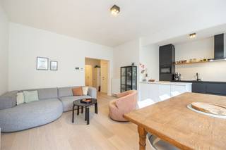 <p><span>Instapklaar, licht én een verrassend grote buitenruimte: dit recent gerenoveerde appartement op de eerste verdieping heeft het allemaal. Je krijgt een mooie leefruimte met open keuken, twee slaapkamers, een strakke badkamer en als absolute bonus een grote, ommuurde tuin. En dat op een strategische locatie vlak bij Park den Brandt, het Middelheimpark en de Wilrijkse Pleinen.</span><span> </span></p><p><span> </span></p><p><span>Licht, open en piekfijn afgewerkt</span></p><p><span>Je komt binnen in de centrale inkomhal, waar plaats is voor een vestiaire. Hier vind je meteen een apart gastentoilet en een praktische berging met aansluitingen voor wasmachine en droogkast. De indeling is logisch en de mooie, lichte parketvloer loopt vrijwel overal door, wat het appartement een rustige, uniforme uitstraling geeft. De woonkamer is aangenaam ruim en vooral heerlijk licht dankzij de grote raampartijen. Er is meer dan voldoende plaats voor een gezellige zithoek én een grote eettafel aan het raam. De open keuken sluit er mooi op aan en is strak ingericht met donkere kasten en een ruim kookeiland met extra opbergruimte. Je hebt hier een inductiekookplaat, dampkap, spoelbak, vaatwasser, combi-oven en koelkast met vriesvak. Een fijne leefplek waar koken, eten en ontspannen vanzelf in elkaar overlopen. </span></p><p><span> </span></p><p><span>Twee slaapkamers en een strakke badkamer</span></p><p><span>Aan de rustige achterzijde vind je de twee slaapkamers. De grootste slaapkamer heeft plaats voor een dubbel bed en een flinke kastenwand, kijkt uit op de tuin en is voorzien van een vliegenraam en automatische rolluiken met afstandsbediening. De tweede kamer is ideaal als kinder- of babykamer, bureau of dressing en heeft eveneens automatische rolluiken. Extra leuk: van hieruit stap je rechtstreeks het terras op, met zicht op het groen. De badkamer is modern en sober afgewerkt met een grote inloopdouche, een zwevend lavabomeubel, spiegel met verlichting en actieve verluchting. De lichte marmerlook tegels en zwarte accenten maken het geheel helemaal af.</span></p><p><span> </span></p><p><span>Een tuin die je niet verwacht bij een appartement</span></p><p><span>En dan de grote verrassing: buiten. Via het terras kom je in de ruime, volledig ommuurde tuin terecht. Een heerlijke plek met veel privacy en meer dan genoeg plaats voor een grote tafel, ligstoelen, planten en groen. Barbecue met vrienden, lang tafelen op zomeravonden of gewoon rustig buiten zitten: hier kan het allemaal. Ook praktisch zit je goed. Op het gelijkvloers hoort er nog een grote privéberging bij, met elektriciteit zodat je er bijvoorbeeld een diepvriezer kunt plaatsen. De tuin is bovendien ook rechtstreeks en privé toegankelijk via het gelijkvloers. </span></p><p><span> </span></p><p><span>Groen wonen en toch overal snel naartoe</span></p><p><span>Je woont hier op de grens van 2020 Antwerpen en 2610 Wilrijk, met opvallend veel groen in de buurt. Park den Brandt en het Middelheimpark liggen vlakbij en ook de Wilrijkse Pleinen met hun uitgebreide sportinfrastructuur zijn vlot bereikbaar. Tegelijk zit je strategisch voor wie vaak onderweg is: belangrijke invalswegen en de op- en afritten van de Ring liggen dichtbij. Zo combineer je hier een groene woonomgeving met een bijzonder vlotte verbinding richting stad en daarbuiten. </span></p><p><span> </span></p>