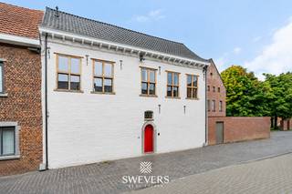 Voor meer info en foto’s, surf naar www.swevers.be – Begijnhof 20 in Sint-Truiden is een volledig gerenoveerde, instapklare woning waar authentieke elementen en hedendaags wooncomfort mooi samenkomen. Hoge plafonds, originele details en het karaktervolle houten gebinte geven de woning een bijzondere uitstraling. Op het gelijkvloers bevinden zich een inkomhal, een zitruimte van 21,5 m² en een ruime keuken van 18,9 m² met plaats voor een grote eettafel. Achteraan sluiten een berging, terras en gemeenschappelijke tuin rechtstreeks aan op de woning. De eerste verdieping telt twee ruime slaapkamers en een centraal gelegen badkamer. Op de tweede verdieping bevinden zich nog twee kamers van 16 m² en 18 m², aangevuld met een speelzolder van 14 m². Deze ruimte kan ook dienstdoen als hobby-, werk- of ontspanningsruimte. Verder beschikt de woning over een kelder van 14,7 m², een wasplaats van 6,6 m² en een fietsenstalling. Het perceel heeft een oppervlakte van 1a 46ca. Dankzij het terras en de gemeenschappelijke tuin geniet je ook in deze centrale omgeving van aangename buitenruimte. De ligging is bijzonder praktisch: winkels en ontspanning liggen op ca. 250 meter, horeca op 200 meter, sportvoorzieningen op 300 meter en een bushalte op slechts 95 meter. Het station bevindt zich op 1,2 km, scholen op 780 meter en kinderopvang op 500 meter. Voor meer informatie, bel 012 699 900. Bron bewoonbare oppervlakte: EPC – verslag.
