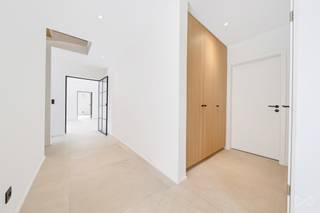 <p>Op slechts enkele minuten van het centrum van Grez-Doiceau onthult deze nieuwbouw een gezinswoning met royale volumes, waar de kwaliteit van de afwerking gepaard gaat met een echte doordachtheid rond comfort en functionaliteit.</p>
<p>Vanaf de inkom herbergt het tuinniveau een hal met vestiaire en gastentoilet, een bureau en een wasruimte. Een polyvalente indeling die, indien nodig, een gelijkvloers leven op dit niveau mogelijk maakt.</p>
<p>Het hart van de woning draait rond een royale open leefruimte die salon, eetkamer en uitgeruste Italiaanse keuken verenigt. Ze geniet van twee buitenruimtes : de tuin aan de ene kant en een in te richten terras aan de andere, ideaal om van de zonsondergangen te genieten. Een tv-ruimte verlengt het salon en biedt een meer intieme ruimte.</p>
<p>Op de verdieping herbergt het nachtgedeelte een ouderslaapkamer met geïntegreerde kasten en een privébadkamer met bad en douche. Twee andere slaapkamers met kasten en een doucheruimte vervolledigen dit niveau.</p>
<p>De bovenste verdieping biedt nog twee grote slaapkamers, die eveneens bureau, speelkamer of vrijetijdsruimte kunnen worden. Volledig onderkelderd beschikt de woning over een garage voor twee wagens, royale opslagruimtes en een bijkomend inrichtingspotentieel. Verschillende parkeerplaatsen zijn beschikbaar voor de woning.</p>
<p>Op twee minuten van het centrum en toch nabij talrijke wandelingen, combineert dit eigendom mooie volumes, verzorgde afwerking en kwaliteit van uitvoering.</p>