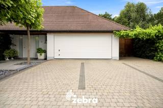 Op het einde van een doodlopende straat ligt deze verzorgde villa in een rustige woonomgeving.<br /><br />Via de inkomhal met ingemaakte vestiaire en gastentoilet wordt u verwelkomd in de woning. Van daaruit komt u terecht in de lichtrijke leefruimte, waar de grote raampartijen zorgen voor een aangenaam ruimtegevoel en een mooi zicht op de tuin. Aansluitend bevindt zich de volledig ingerichte open keuken met onder andere een vaatwasser, oven, microgolfoven, stoomoven, keramische kookplaat en een amerikaanse koelkast. De gezellige ontbijthoek en de ingemaakte berging maken het geheel compleet.<br /><br />Verder beschikt het gelijkvloers over een inkomhal die toegang geeft tot twee slaapkamers, een eerste badkamer en een ruime garage van 26 m² met automatische poort. Op de oprit is bovendien plaats voor meerdere wagens.<br /><br />Deze praktische indeling maakt de woning uitermate geschikt voor wie wonen en werken wil combineren of het comfort van gelijkvloers wonen weet te appreciëren.<br /><br />Op de verdieping bevinden zich nog twee ruime slaapkamers, waarvan één uitgeeft op een zonnig, zuidgericht dakterras. Daarnaast is er een tweede badkamer aanwezig, wat extra comfort biedt voor gezinnen of gasten.<br /><br />Deze tijdloze villa combineert een praktische indeling, veel natuurlijk licht en een uitstekende ligging in een rustige, residentiële buurt. Een ideale thuis voor wie op zoek is naar ruimte, comfort en een vlot bereikbare locatie.<br /><br /><strong>Ook wild geworden van deze thuis?<br />Twijfel dan niet langer en leg vandaag nog uw bezoek vast!</strong>