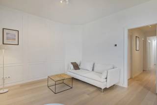 In een kleinschalig historisch, doch volledig gerenoveerd gebouw vinden we op de tweede verdieping dit ruime en bijzonder sfeervolle appartement met twee riante slaapkamers.<br /><br />Bij het binnenkomen vallen meteen de mooie parketvloer, de verzorgde afwerking en het warme karakter van het appartement op. Dankzij de ligging op de tweede verdieping geniet de leefruimte aan de voorzijde van een aangenaam open uitzicht over de omliggende bebouwing en richting het plein voor de Onze-Lieve-Vrouw-Geboortekerk. Het vrije zicht draagt bij aan het aangename gevoel van ruimte en rust.<br /><br />Aansluitend aan de leefruimte bevindt zich de open en volledig uitgeruste keuken met een gezellig eiland. De warme parketvloer werd doorgetrokken doorheen nagenoeg het volledige appartement, met uitzondering van de vochtige ruimtes, en vormt samen met de hedendaagse afwerking een mooi en harmonieus geheel.<br /><br />Via de nachthal bereiken we de twee riante slaapkamers. Eén slaapkamer bevindt zich aan de zijde van de d’Urselstraat, terwijl de tweede slaapkamer aan de achterzijde van het gebouw gelegen is. In de nachthal werd bovendien een functionele bergkast voorzien. De ruime badkamer is uitgerust met een comfortabele inloopdouche en geniet dankzij de lichtkoepel van aangenaam natuurlijk daglicht. Verder beschikt het appartement over een afzonderlijk toilet.<br /><br />Ook praktisch heeft deze woonst heel wat te bieden. In de kelderverdieping beschikt het appartement over een private kelderberging en in de gemeenschappelijke inkomhal is een fietsenberging voorzien.<br /><br />Een appartement dat sfeer en gezelligheid uitstraalt, met royale ruimtes, twee volwaardige slaapkamers en een aangenaam open uitzicht. Het historische karakter van het gebouw werd op een geslaagde manier gecombineerd met hedendaags wooncomfort, wat resulteert in een charmant appartement met een geheel eigen karakter.<br /><br />Last but not least: gunstig EPC label A: 48kwh/m² + conforme elektriciteit én individuele zonnepanelen!<br /><br />Heeft u interesse in dit appartement? Neem dan contact met het kantoor van VB Vastgoed Hoboken op het nummer 03 337 50 70 of via info@vbvastgoed.be <br />