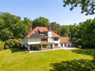 <span>Kasteeldreef 38 - 2950 Kapellen Deze karaktervilla werd gebouwd omstreeks 1937 en is omgeven door een prachtige parktuin van ca 10.812 m² met prachtige aanplantingen en oude monumentale bomen. Het is een klassieke Franse stijl villa die steeds tip top werd onderhouden en verschillende mogelijkheden biedt. De woning straalt enorm veel grandeur en charme uit en werd in ... grondig gerenoveerd. De villa is als volgt ingedeeld: Royale inkomhal op tegelvloer met gastentoilet met handenwasser en vestiairekast. Doorgang naar ruime leefruimte met gashaard, veel ramen en natuurlijke lichtinval. Toegang tot overdekt terras. Hiernaast bevindt zich nog een tweede leefruimte of eetkamer met zicht op tuin en terras en gashaard. Aansluitend bevindt zich nog een open ruimte die momenteel wordt gebruikt als kantoor. Verder komt u in de volledig ingerichte keuken, voorzien van alle toestellen en ingemaakte kasten + ontbijthoek. Naast de keuken is er nog een grote polyvalente ruimte, momenteel gebruikt als kantoor of vergaderruimte, weer met grote raampartijen die uitgeven op de mooie parktuin. Naast de keuken toegang tot de ruime garage die plaats biedt voor 3a4 wagens. Hiernaast bevindt zich nog een badkamer met wc, douche en lavabo die hoort bij een gastenverblijf of conciërge kamer op de eerste verdieping (met aparte ingang via de keuken). Via de trap in de inkomhal toegang tot de eerste verdieping die als volgt is ingedeeld: 1e slaapkamer met aansluitend badkamer met ligbad, douche, dubbele lavabo en wc met marmer bekleed. 2e slaapkamer op vast tapijt. 3e en 4e slaapkamer op vast tapijt. Hoofdslaapkamer op vast tapijt met aansluitend hoofd badkamer met ligbad, douche, dubbele lavabo en wc. Hiernaast bevindt zich nog een aparte kamer die dienst doet als wasplaats. Via de vaste zoldertrap toegang tot de zolderverdieping die is afgewerkt en onderverdeeld in 3 kamers en een berging. Via een zolderluik nog toegang tot de bergzolder. Via de keuken is er tevens toegang tot de ruime en volwaardige kelderverdieping onderverdeeld in verschillende ruimtes: wijnkelder, technische ruimte, bergruimtes,... De ruime oprit en parking bieden plaats voor een achttal wagens. Hier is tevens een bijgebouw opgetrokken van ca 80m². Deze voormalige garage wordt nu gebruikt als seminarie ruimte en is voorzien van sanitair en elektriciteit. In de tuin werd nog een uniek kunstwerk ontworpen dat als polyvalente ruimte kan dienen. Een ideale ruimte om tot rust te komen volledig omgeven door de natuur en de parktuin. De woning met garages en bijgebouw zorgen voor zeer veel potentieel en verschillende mogelijkheden qua invulling: ruime gezinswoning, kantoor aan huis, kangoeroe wonen, conciërgewoning, kantoren,...</span>